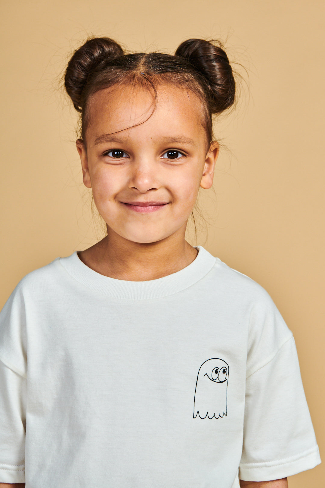 Young girl wearing short sleeve t shirt plastic free in bone with ghost print on chest