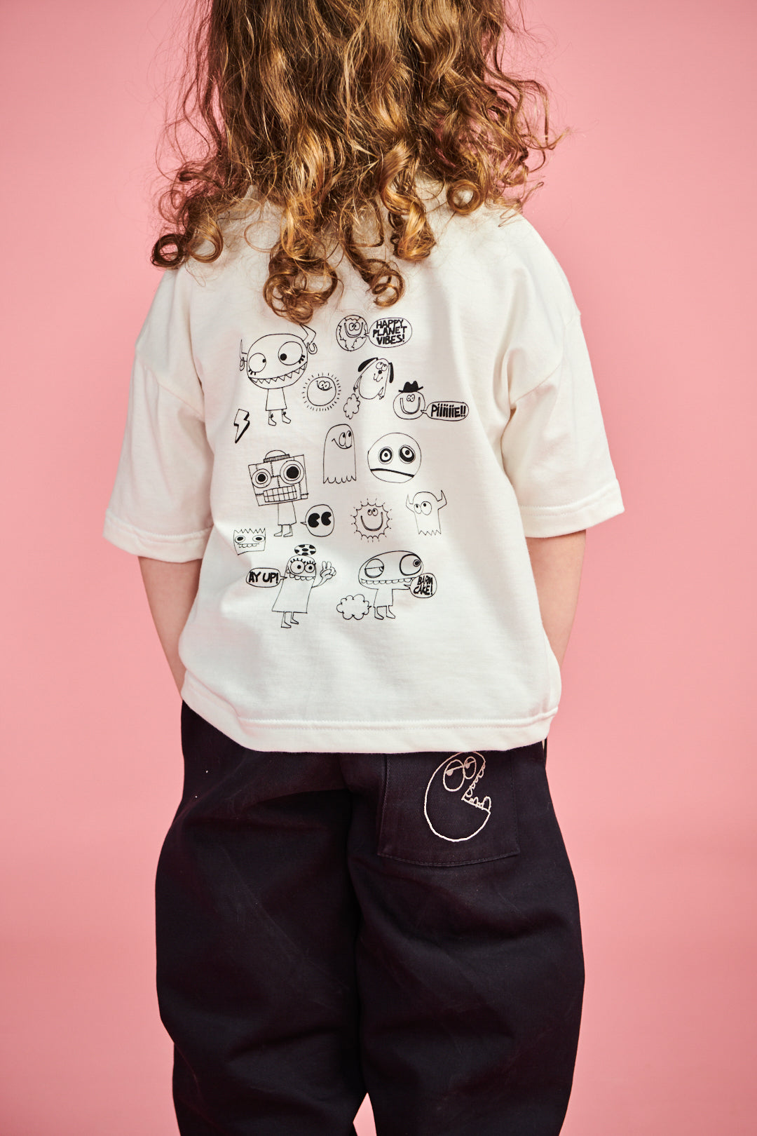 The back of young boy wearing short sleeve t shirt plastic free in bone with print on he back