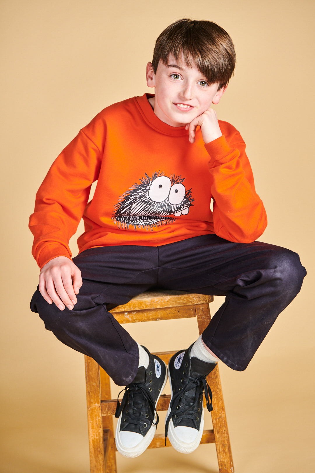 Boy wearing plastic free sweatshirt in flame red with Boffles print on front