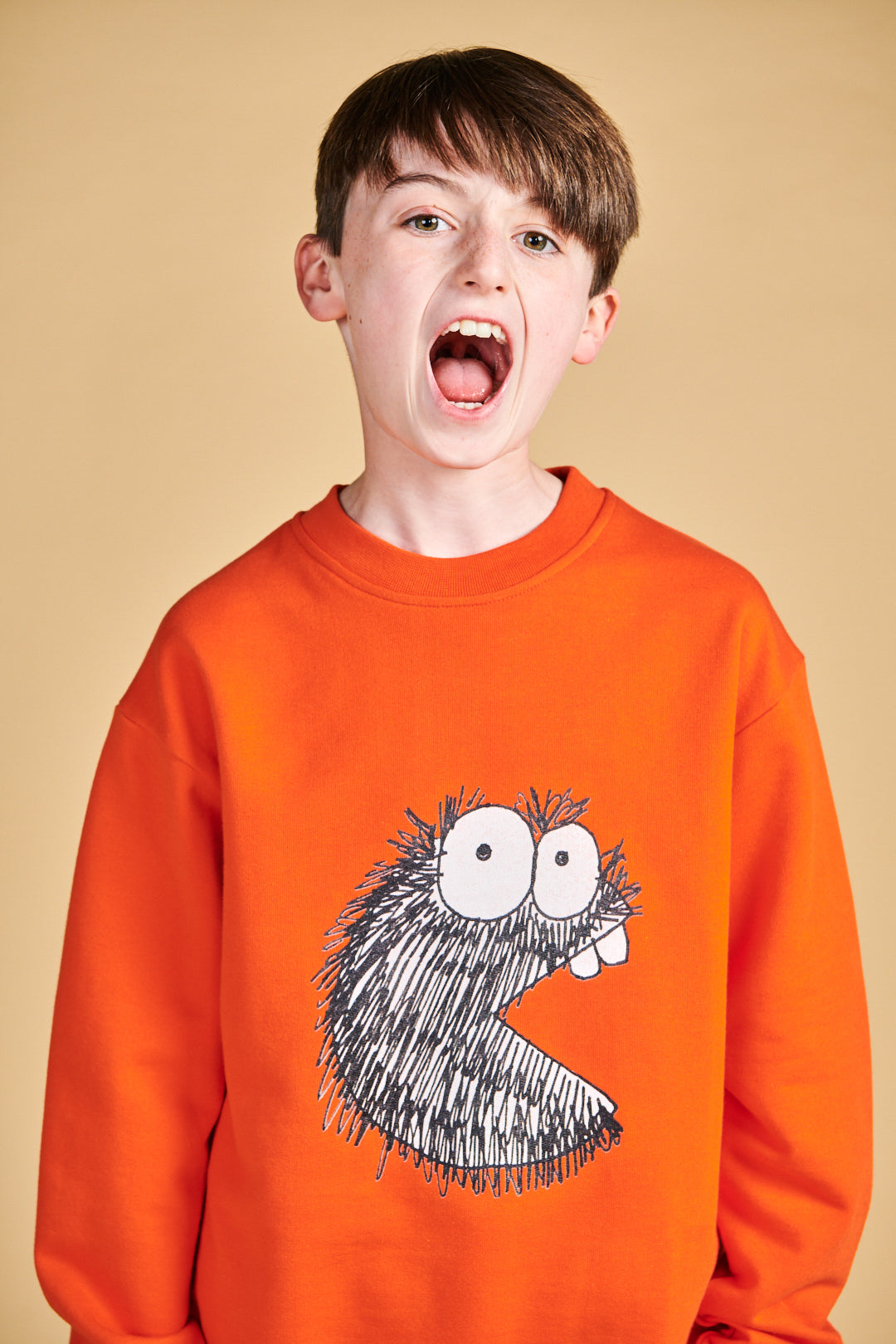Boy wearing plastic free sweatshirt in flame red with Boffles print on front