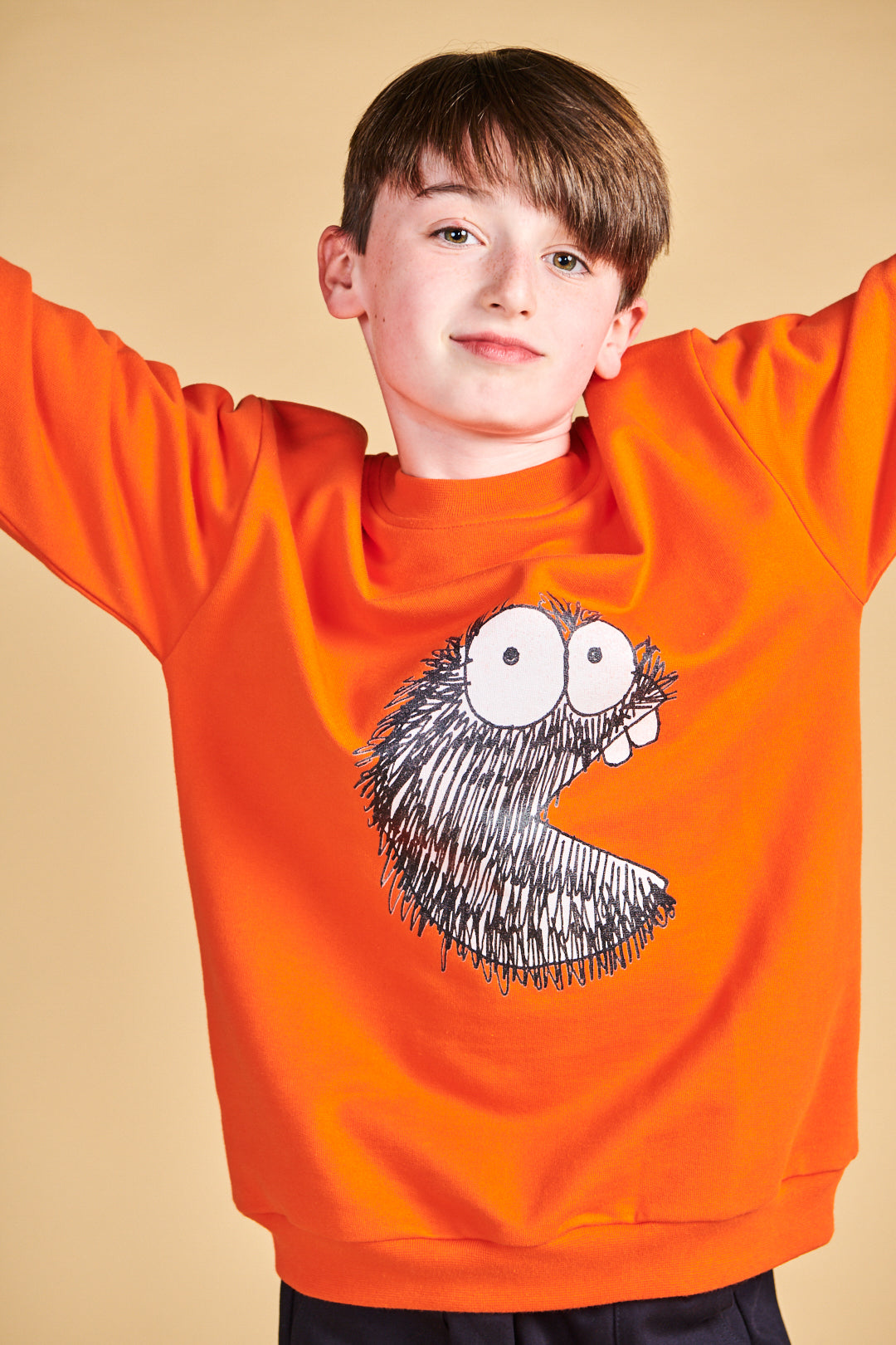 Boy wearing plastic free sweatshirt in flame red with Boffles print on front