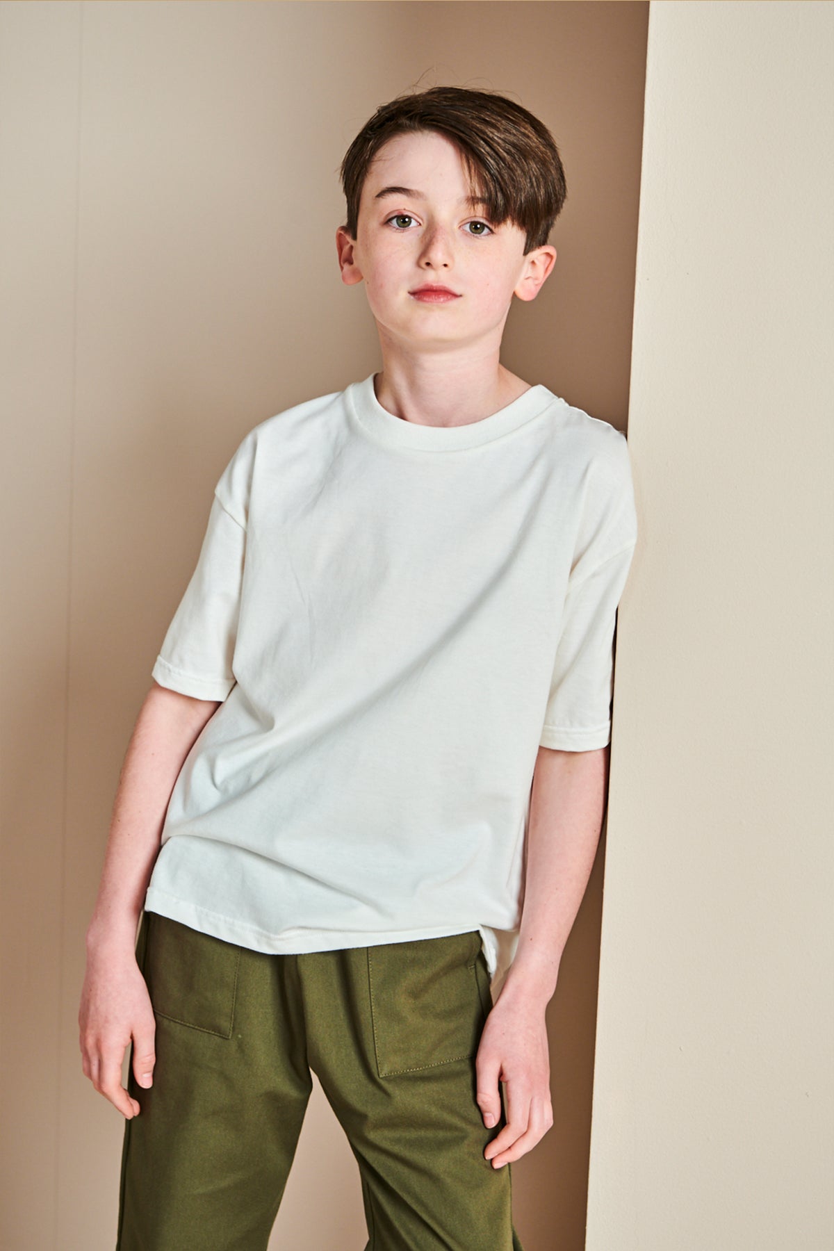 Young boy wearing short sleeve t shirt in bone