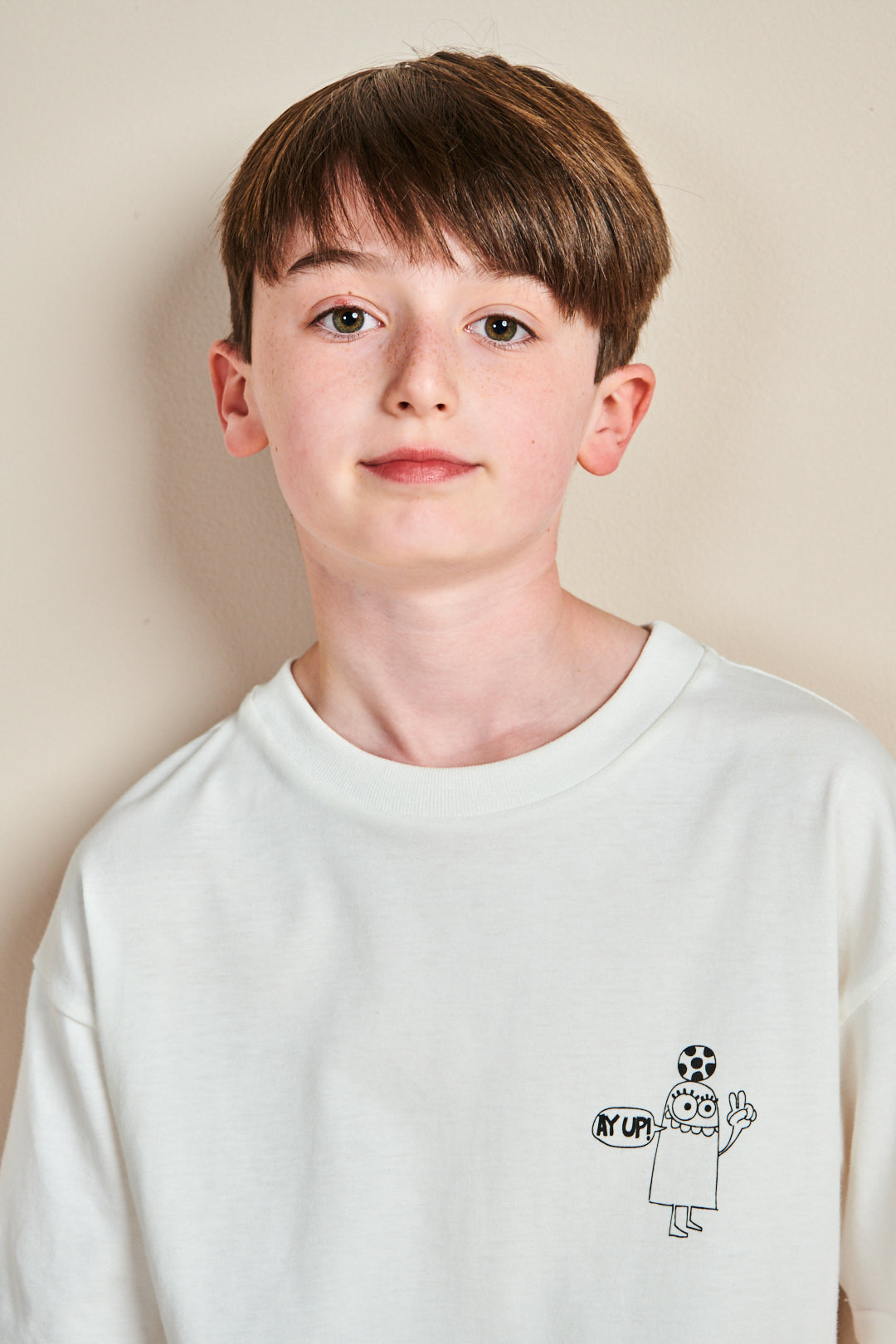 Boy wearing short sleeve t shirt in bone with Ay up print on