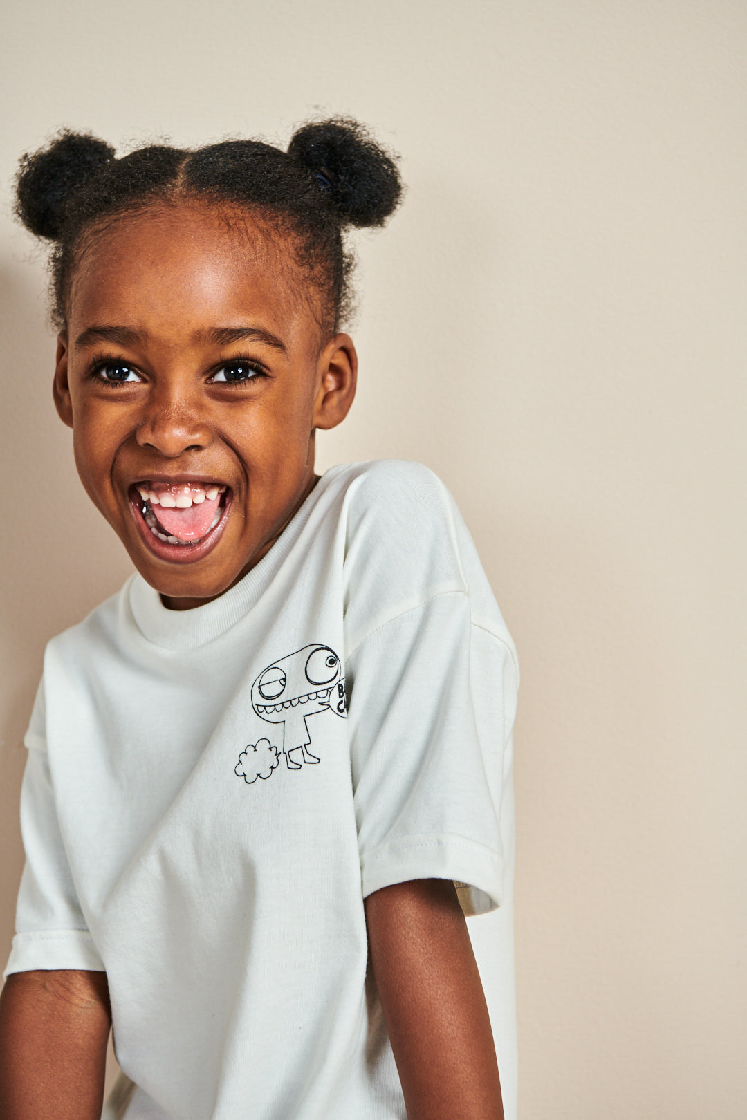 Smiley young girl wearing short sleeve t shirt in bone with barm cake! print on chest