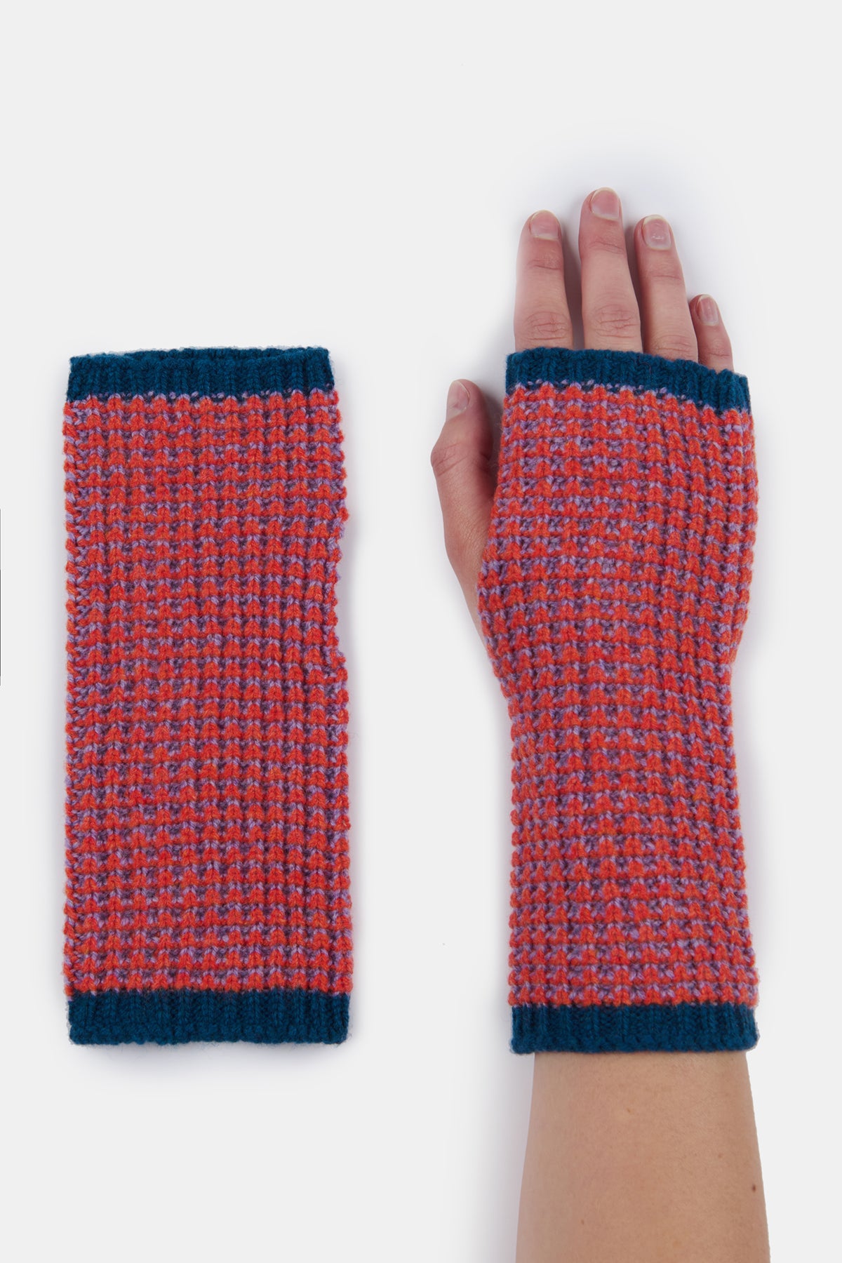 
            Flatlay of the left hand lambswool fingerless waffle gloves in flame next to hand model wearing the right hand glove