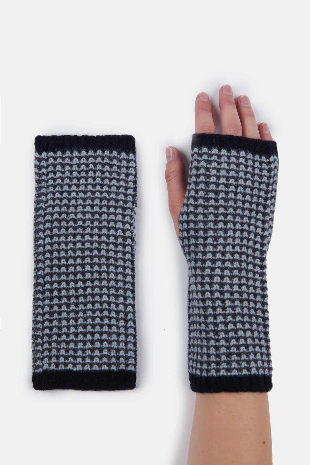 
            Flatlay of the left hand lambswool fingerless waffle gloves in flame next to hand model wearing the right hand glove