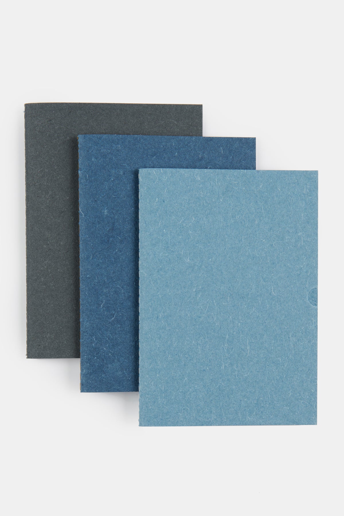 
            Set of three A5 recycled denim notebooks. Black, indigo and blue