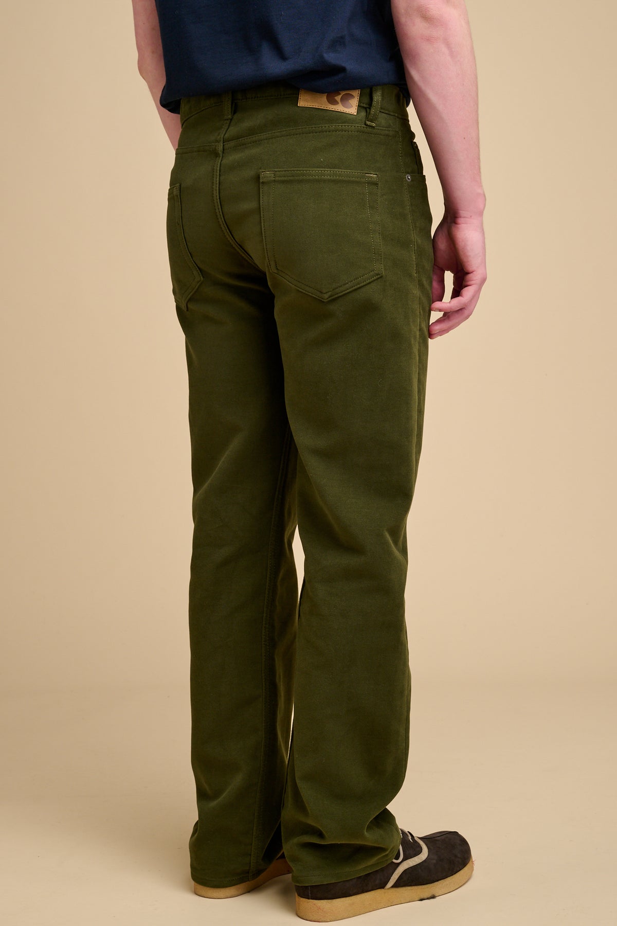 The back of male dark olive wearing moleskin jeans.