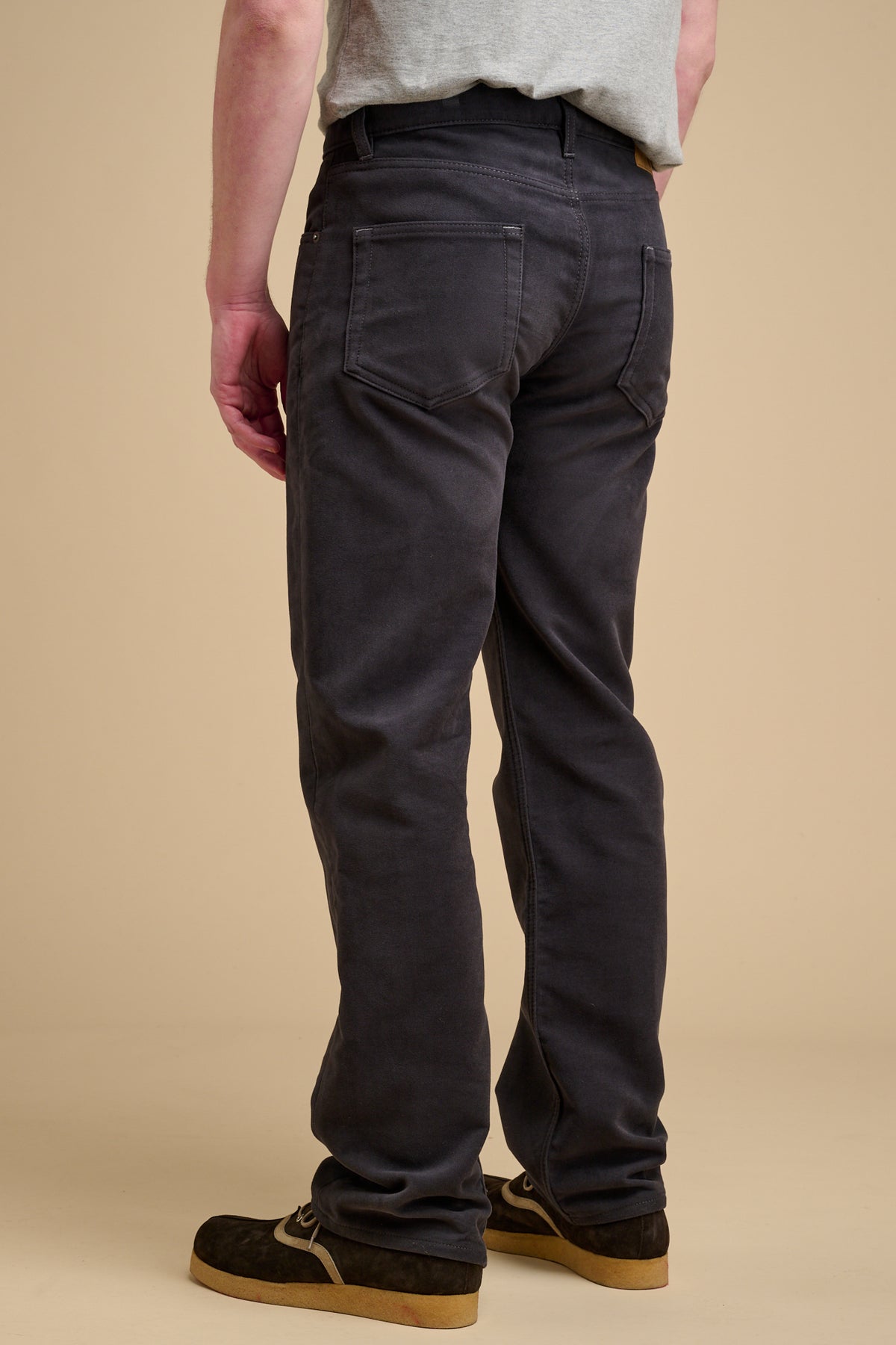 The back of male wearing moleskin jeans in slate grey.
