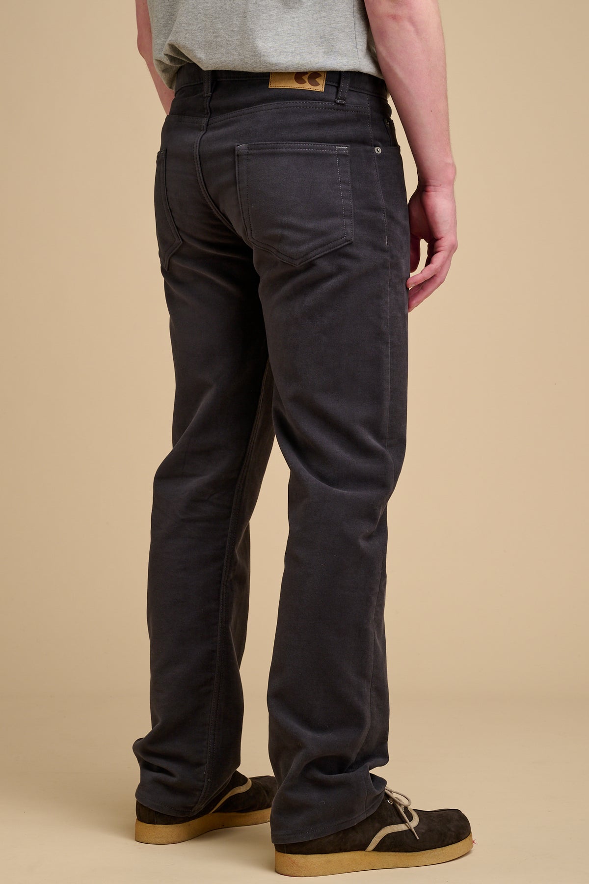 The back of male wearing moleskin jeans in slate grey.