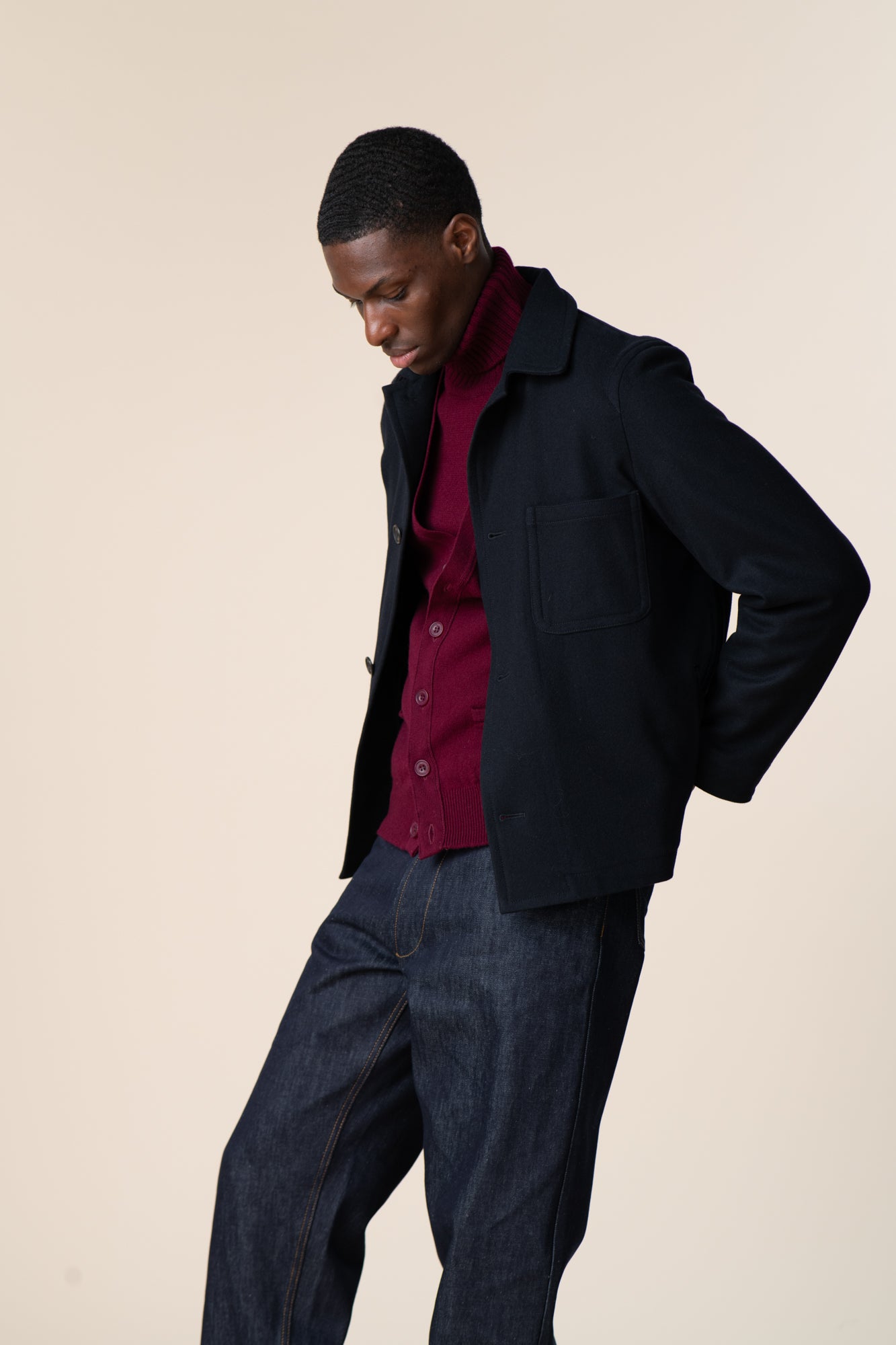 Black male wearing Arthur wool chore jacket in navy, layered over lambswool roll neck in burgundy, paired with chore jeans in indigo