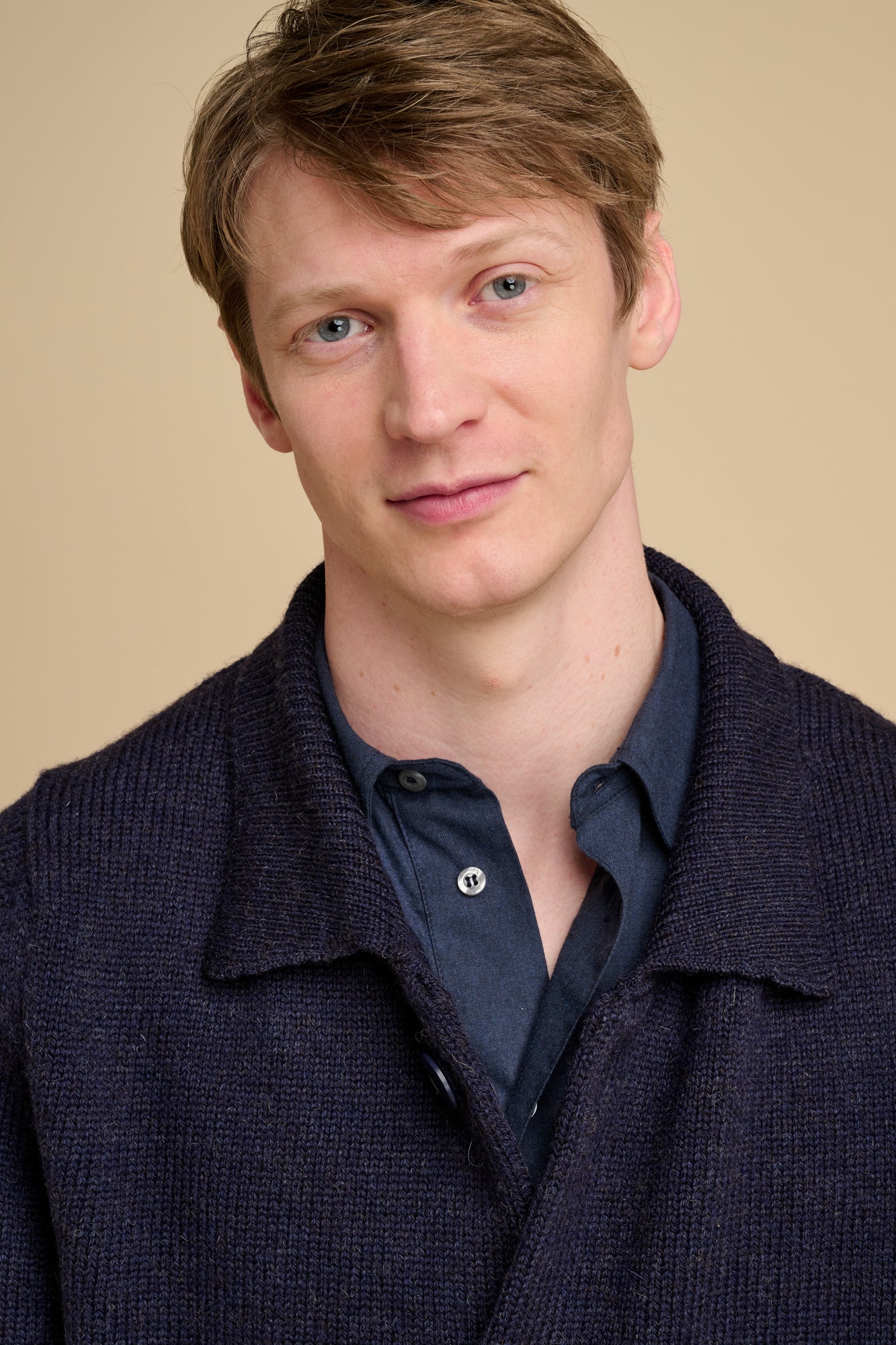 Man wearing navy cardigan over navy shirt.