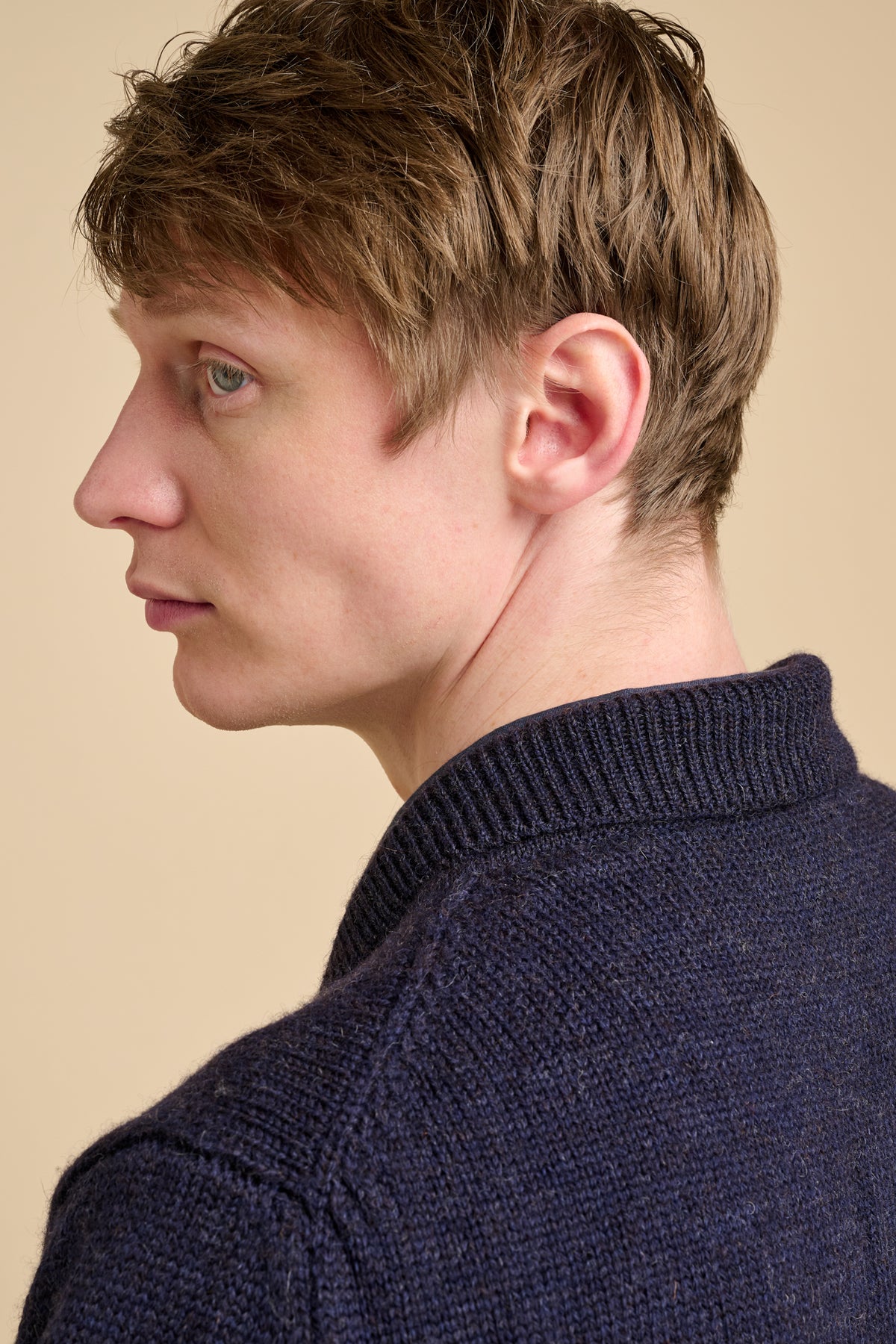 The back of male wearing navy cardigan.