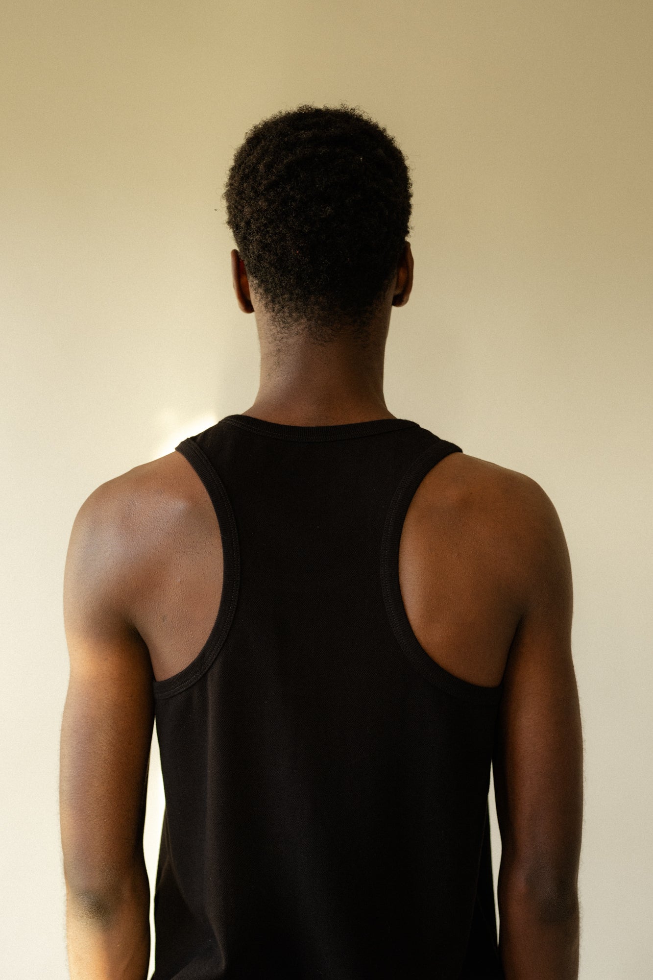 back of male wearing breathable racer back vest plastic free in black