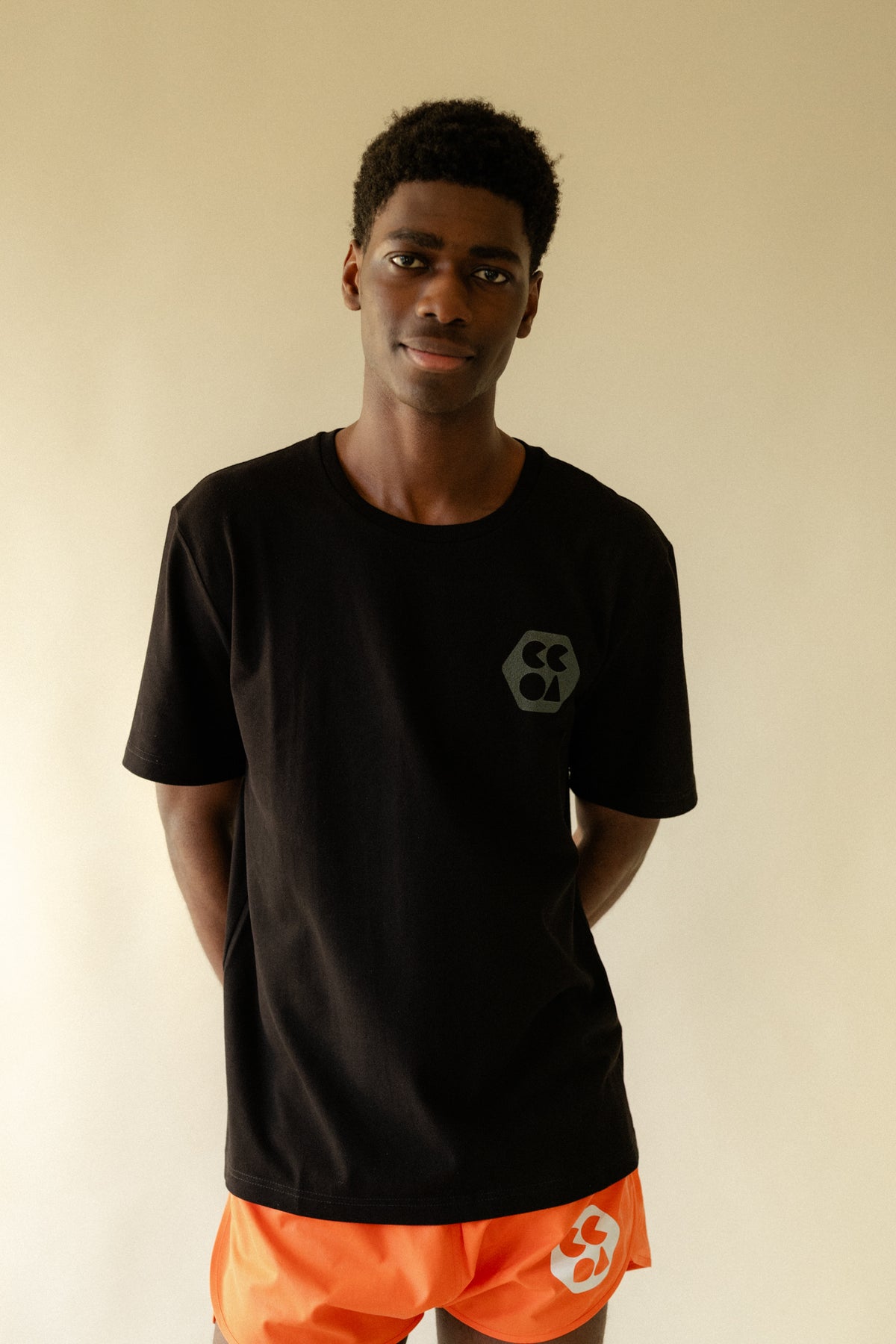 
            Black male wearing breathable short sleeve t shirt in black with CCOA logo