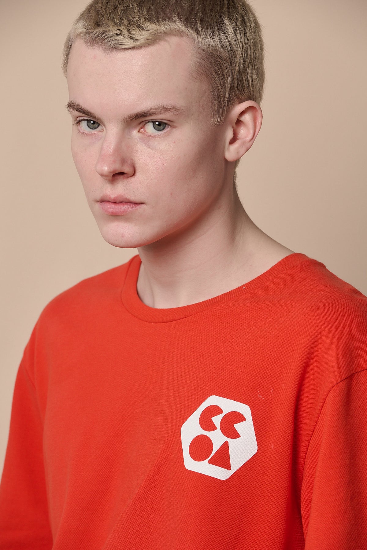 Portrait of male wearing breathable t shirt plastic free in flame red with CCOA logo