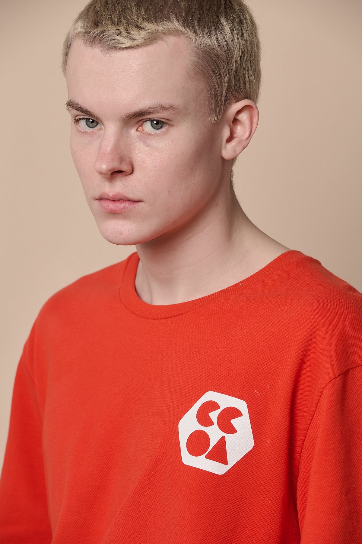 
            Portrait of male wearing breathable t shirt plastic free in flame red with CCOA logo