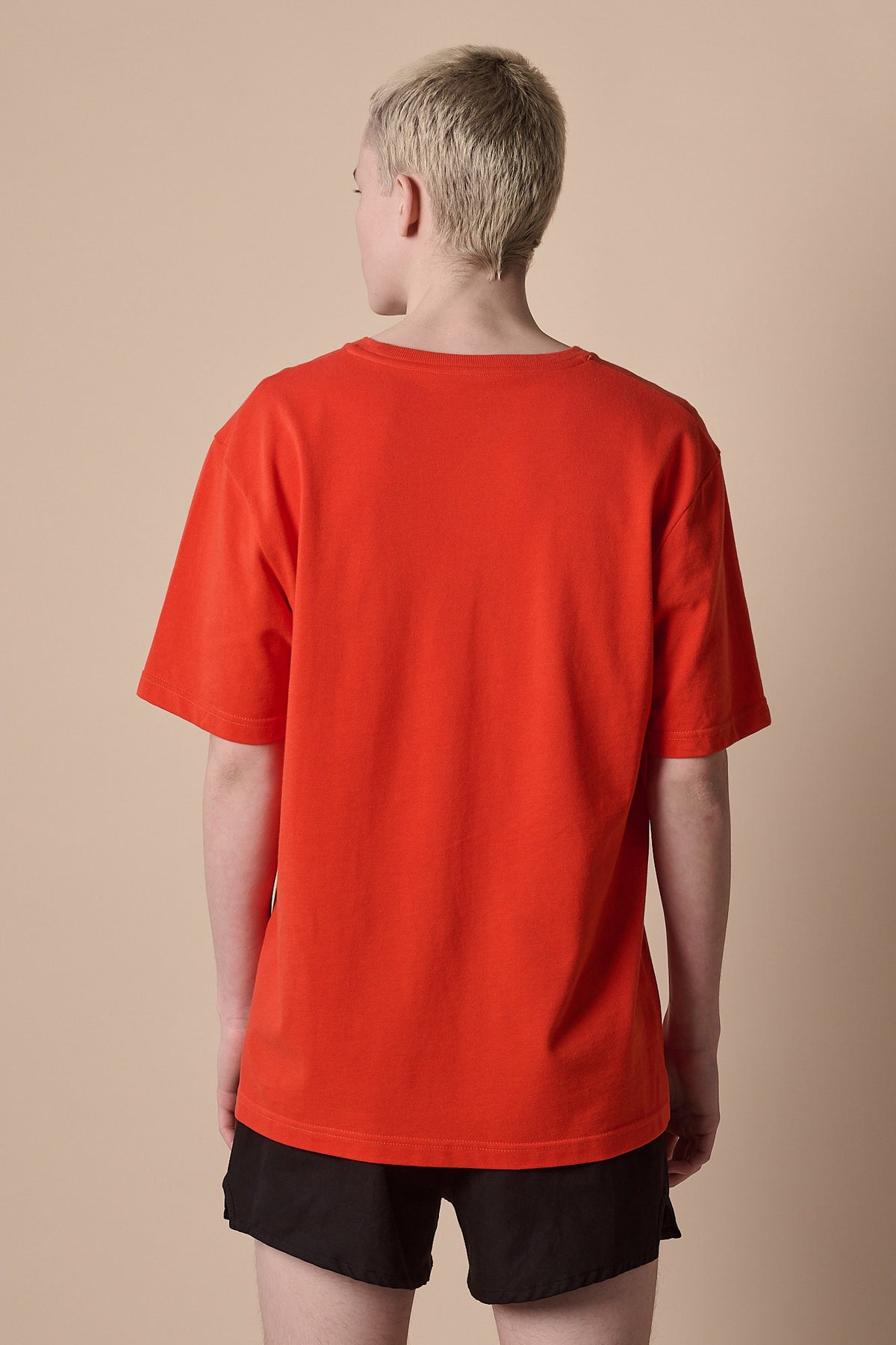 
            Image of the back of male wearing breathable t shirt plastic free in flame red with CCOA logo