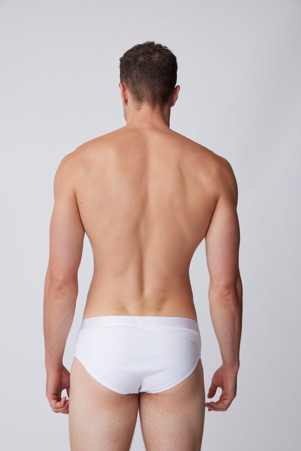 black male facing away showing the back of white underwear brief