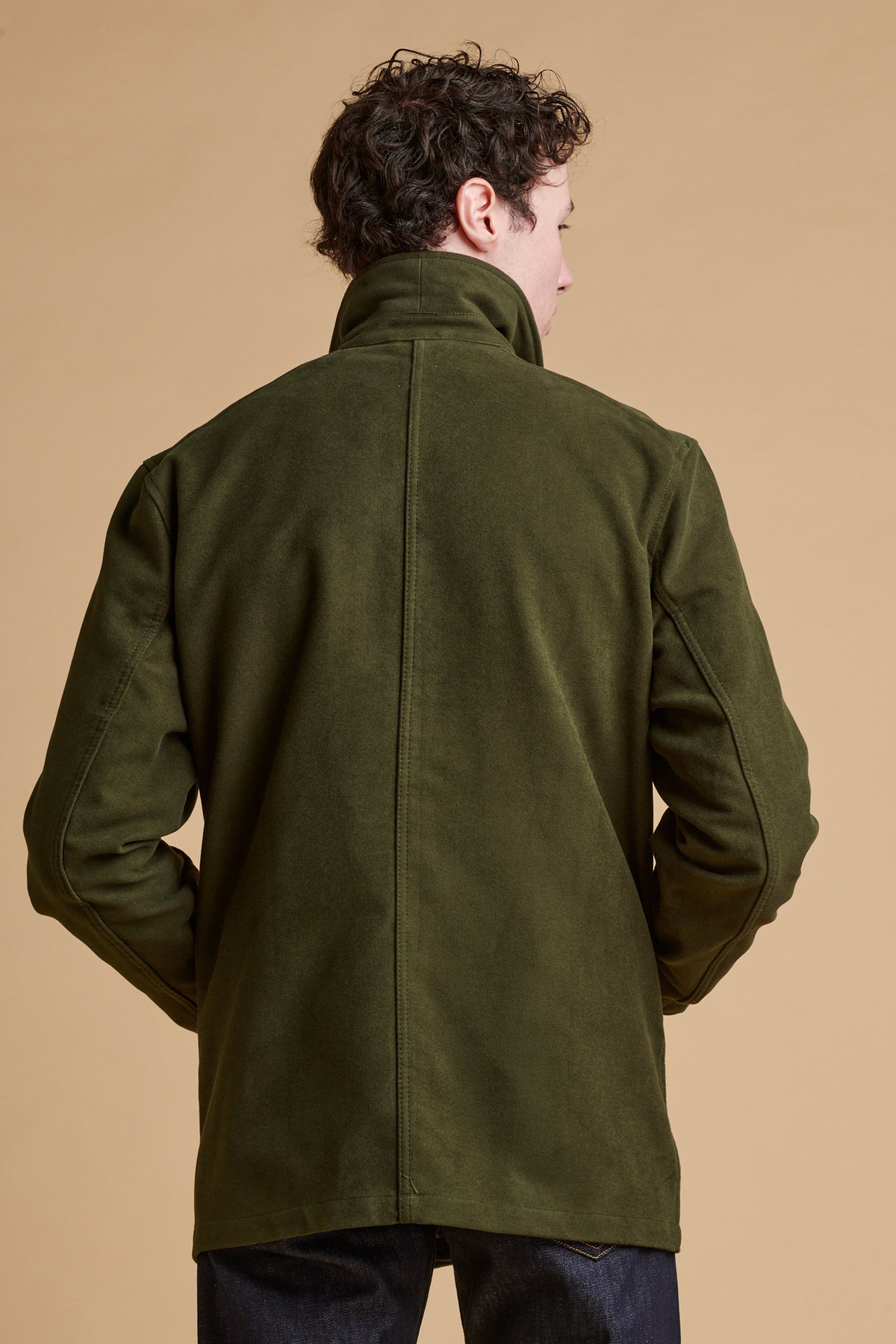 The back of male wearing Carter moleskin chore jacket in dark olive.