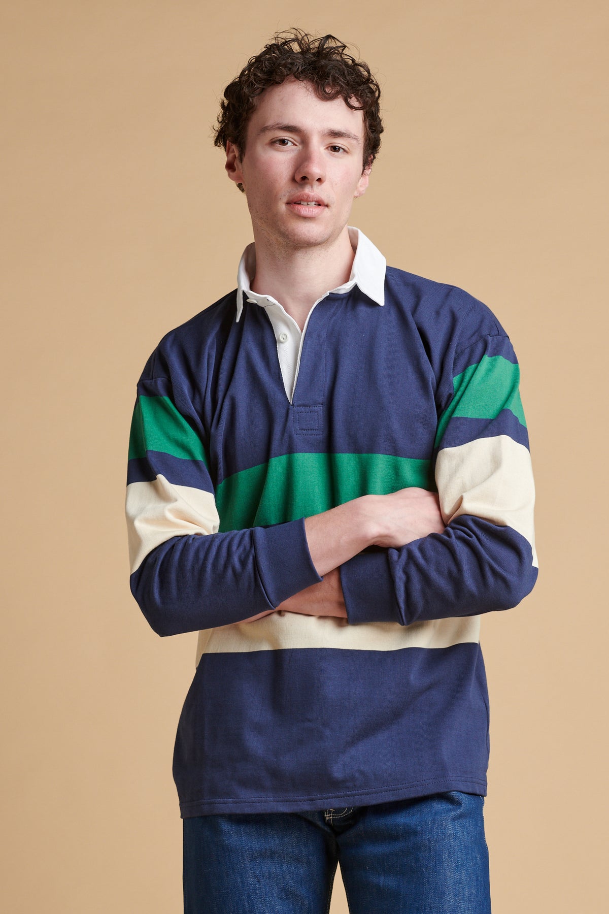 Male wearing chest striped rugby shirt in ecru navy bottle green.