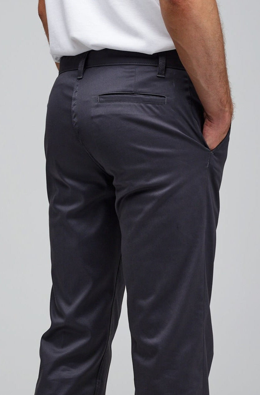 Back of male wearing slim stretch chino in slate grey rolled hem with hands in pocket