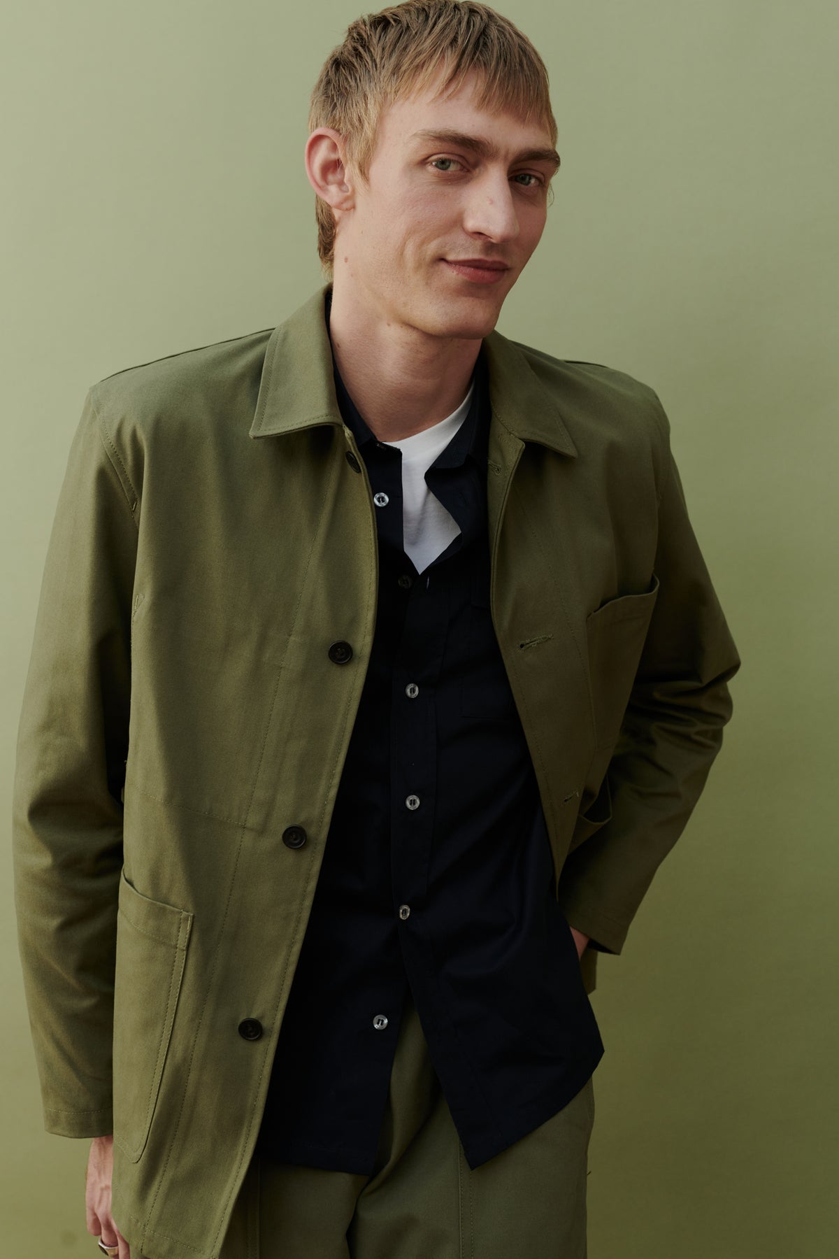 Image of white male, waist up wearing men's chore jacket in olive