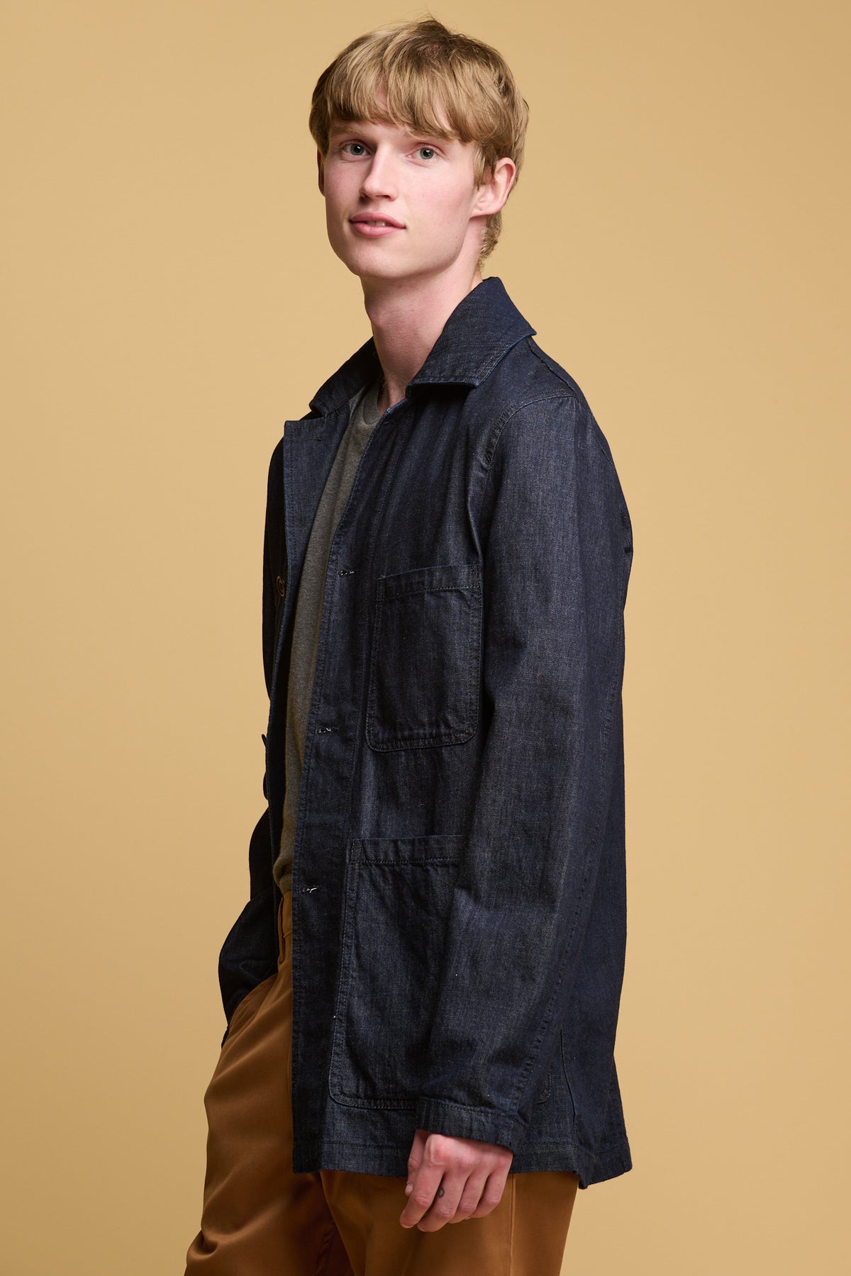 
            Thigh up of male wearing chore jacket in indigo denim 