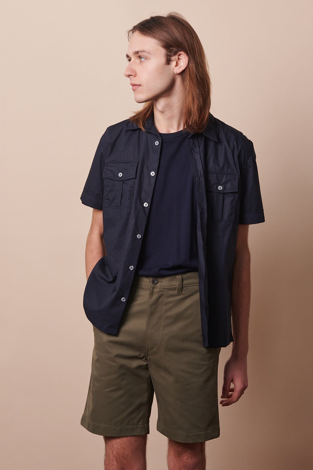 Knee up image of male wearing classic shorts in olive paired navy military shirt layered over short sleeve navy t shirt