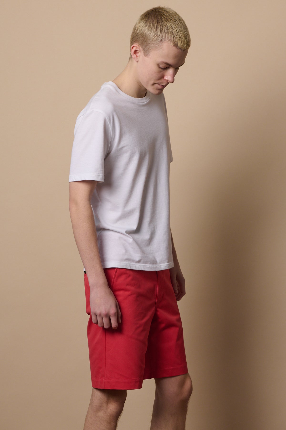 Thigh up of male wearing salmon red cotton shorts