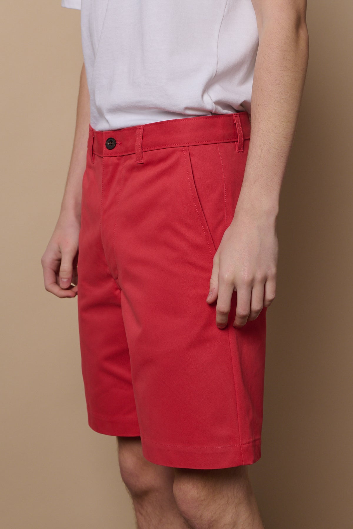 Front details of salmon red shorts, two pockets and belt loops on waistband