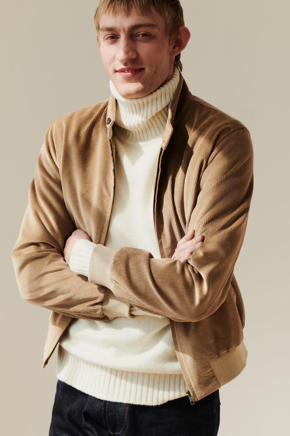 Male wearing men's corduroy harrington jacket in stone layered over lambswool roll neck jumper in ecru