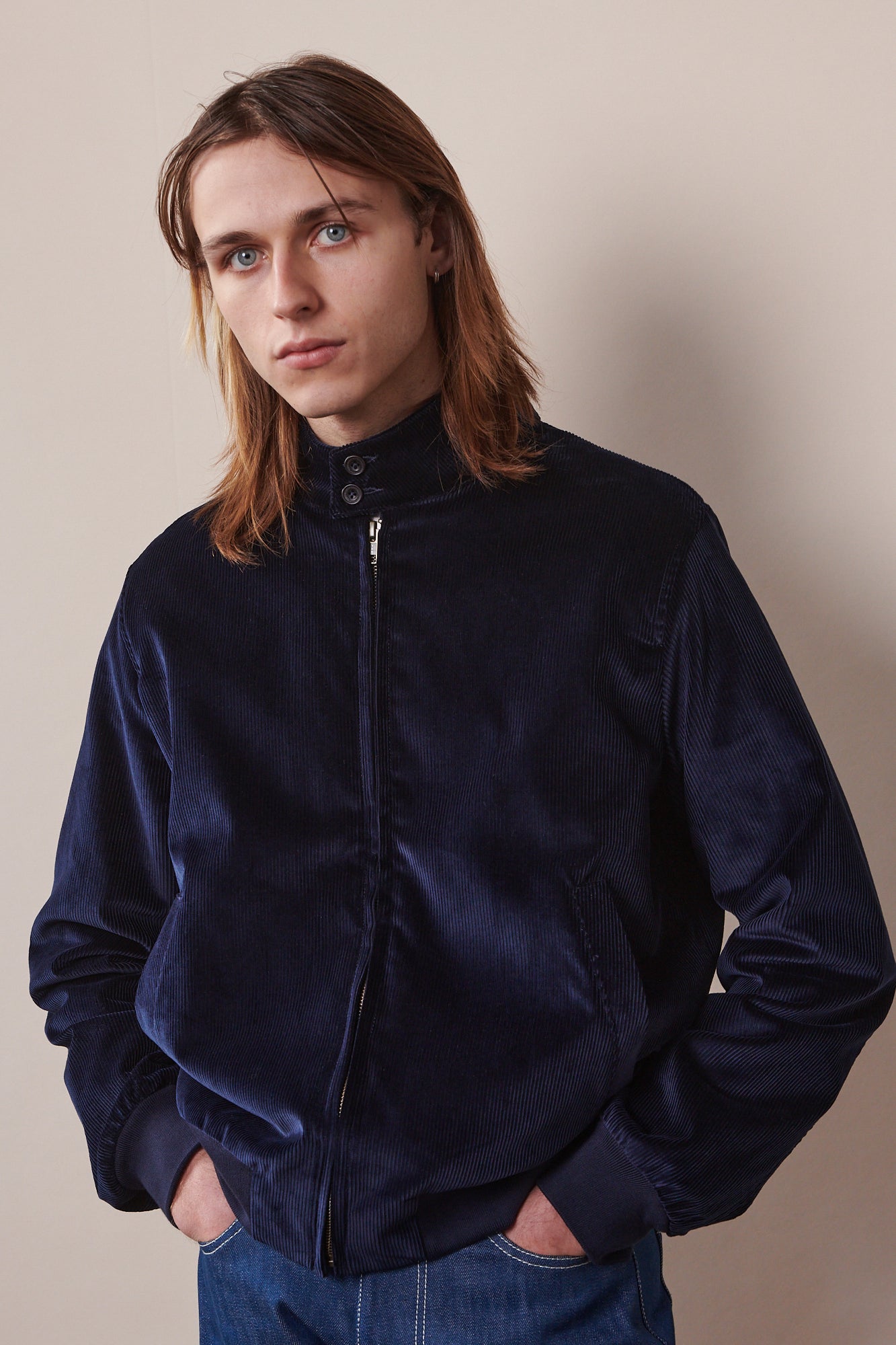 male wearing zipped corduroy Harrington with hands in jeans pockets