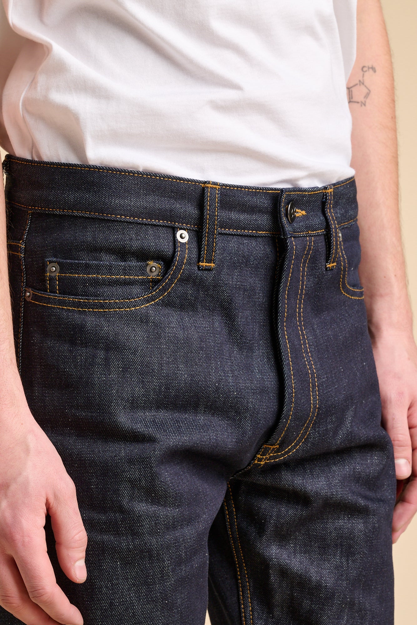 Close up of man wearing jeans in indigo with coin pocket.
