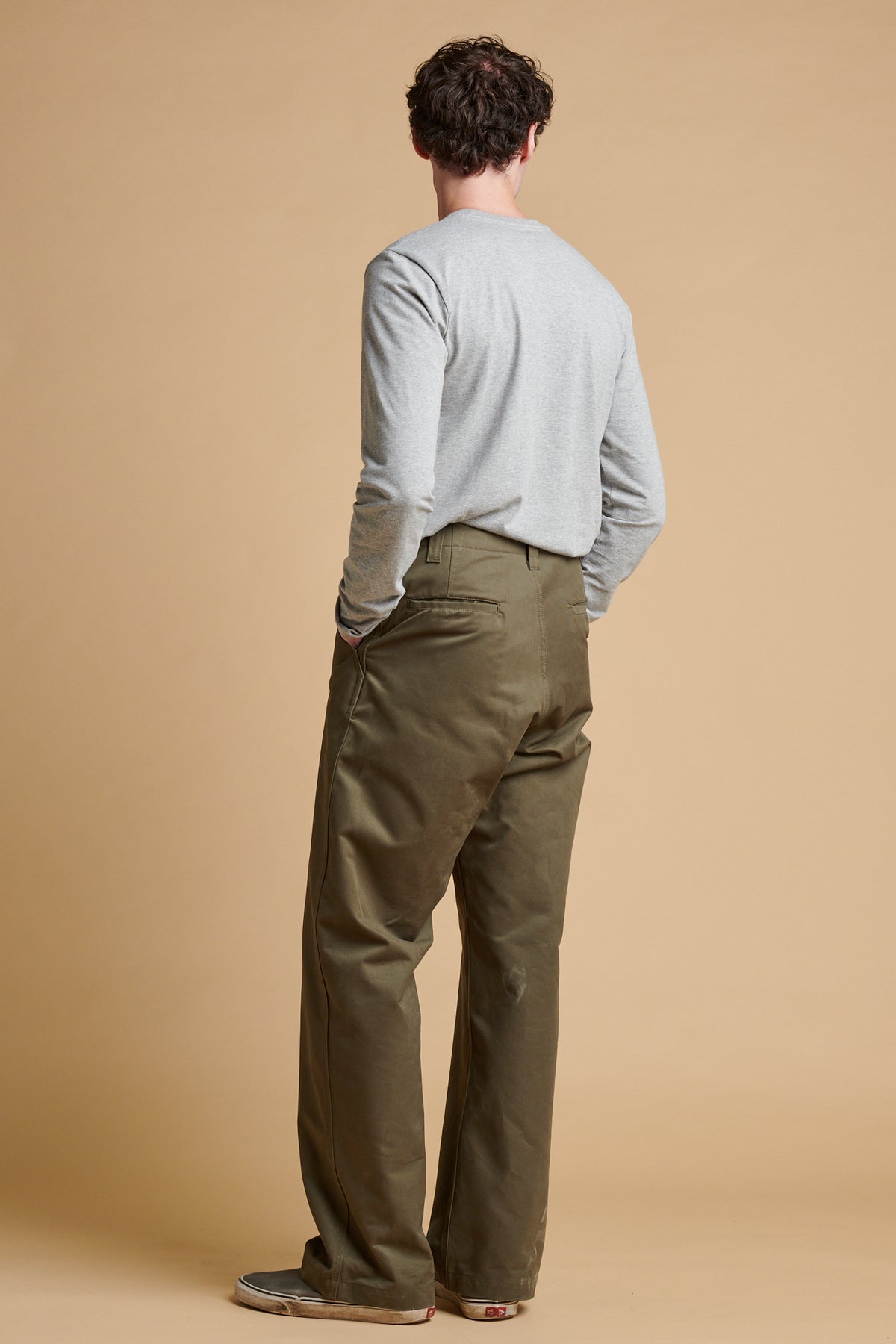 The back of male wearing field trousers in olive.