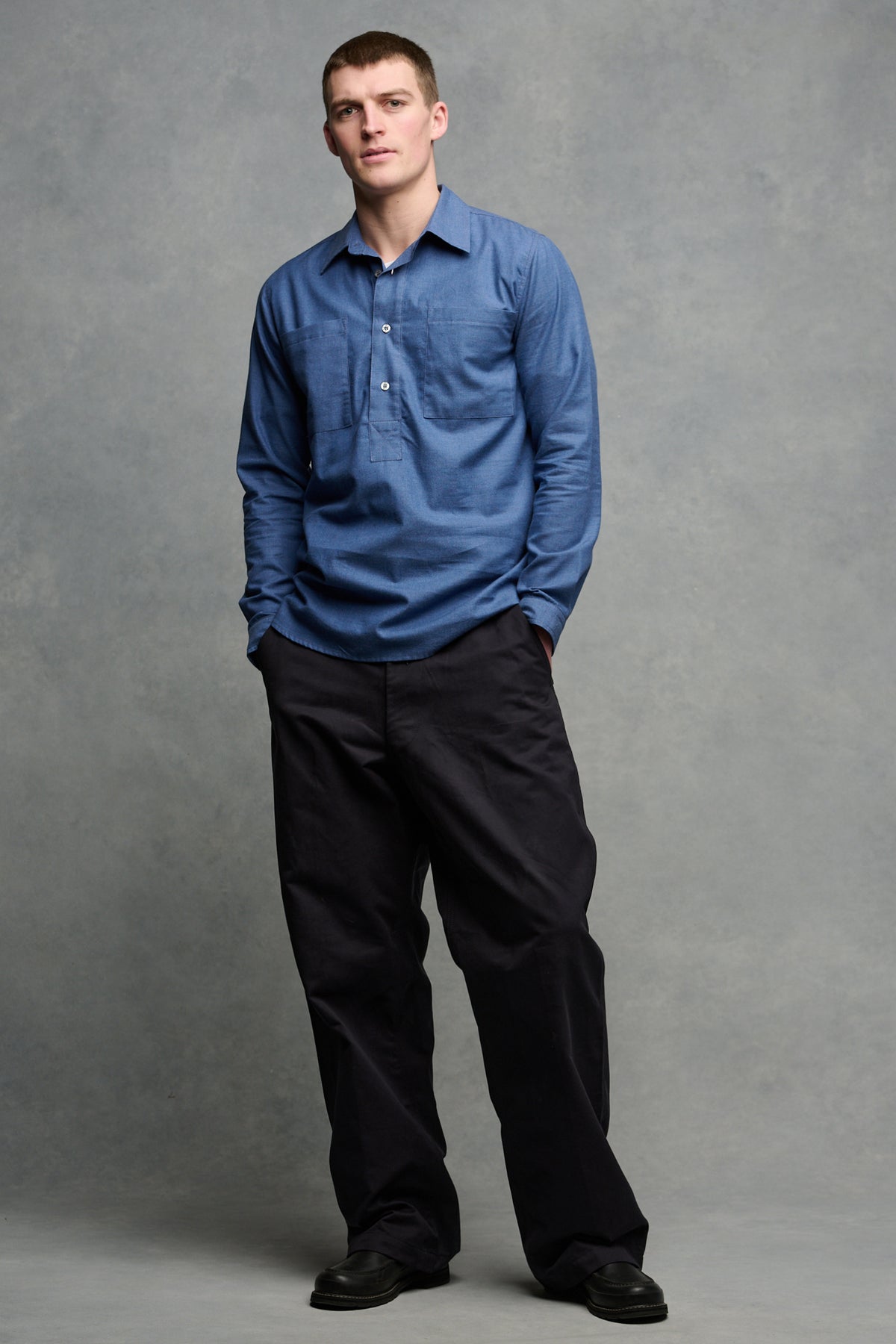 Full body image of the front of male wearing field trousers in navy paired with Oli half placket lightweight shirt in RAF Blue