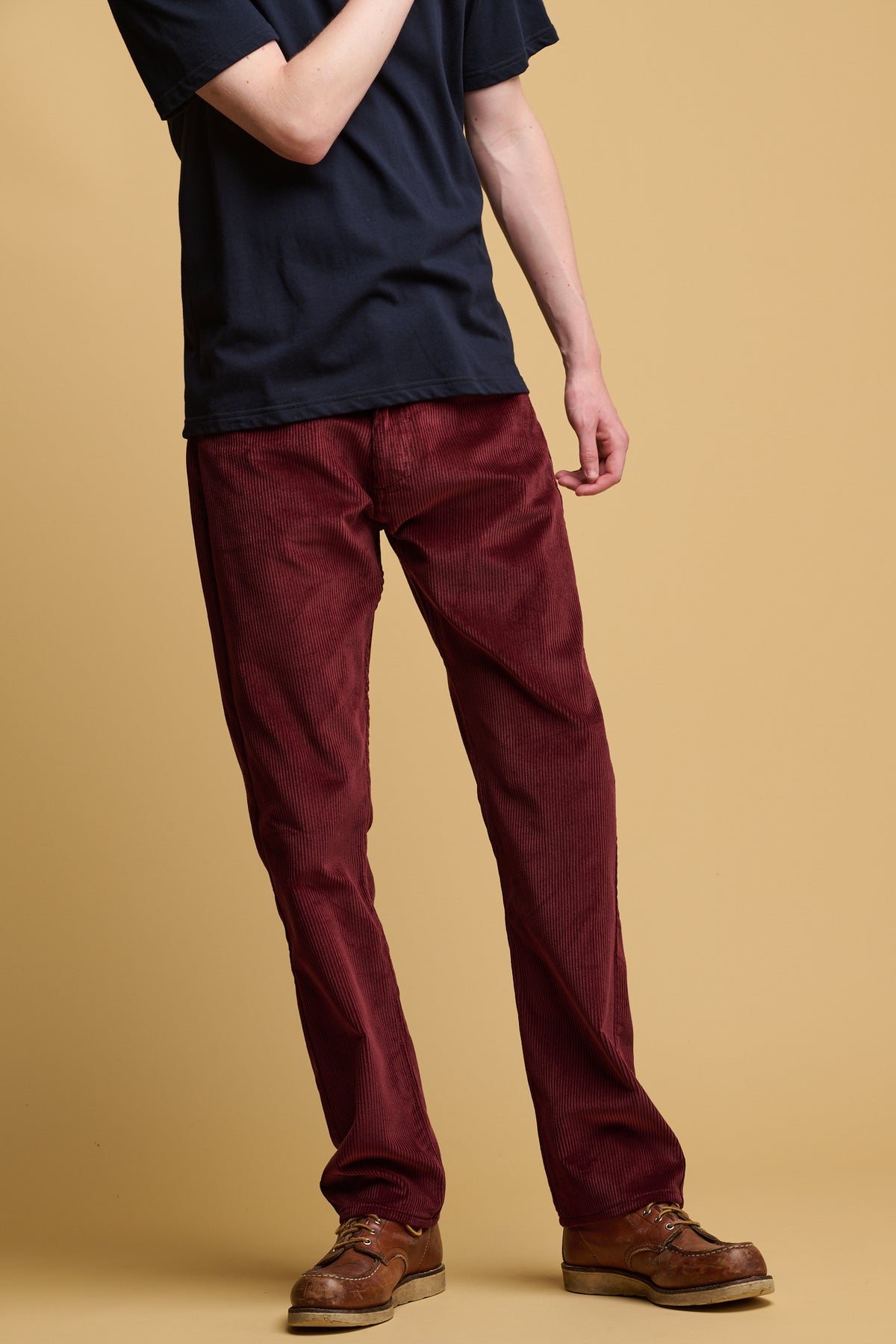 Shoulder down of male wearing cord trousers in burgundy