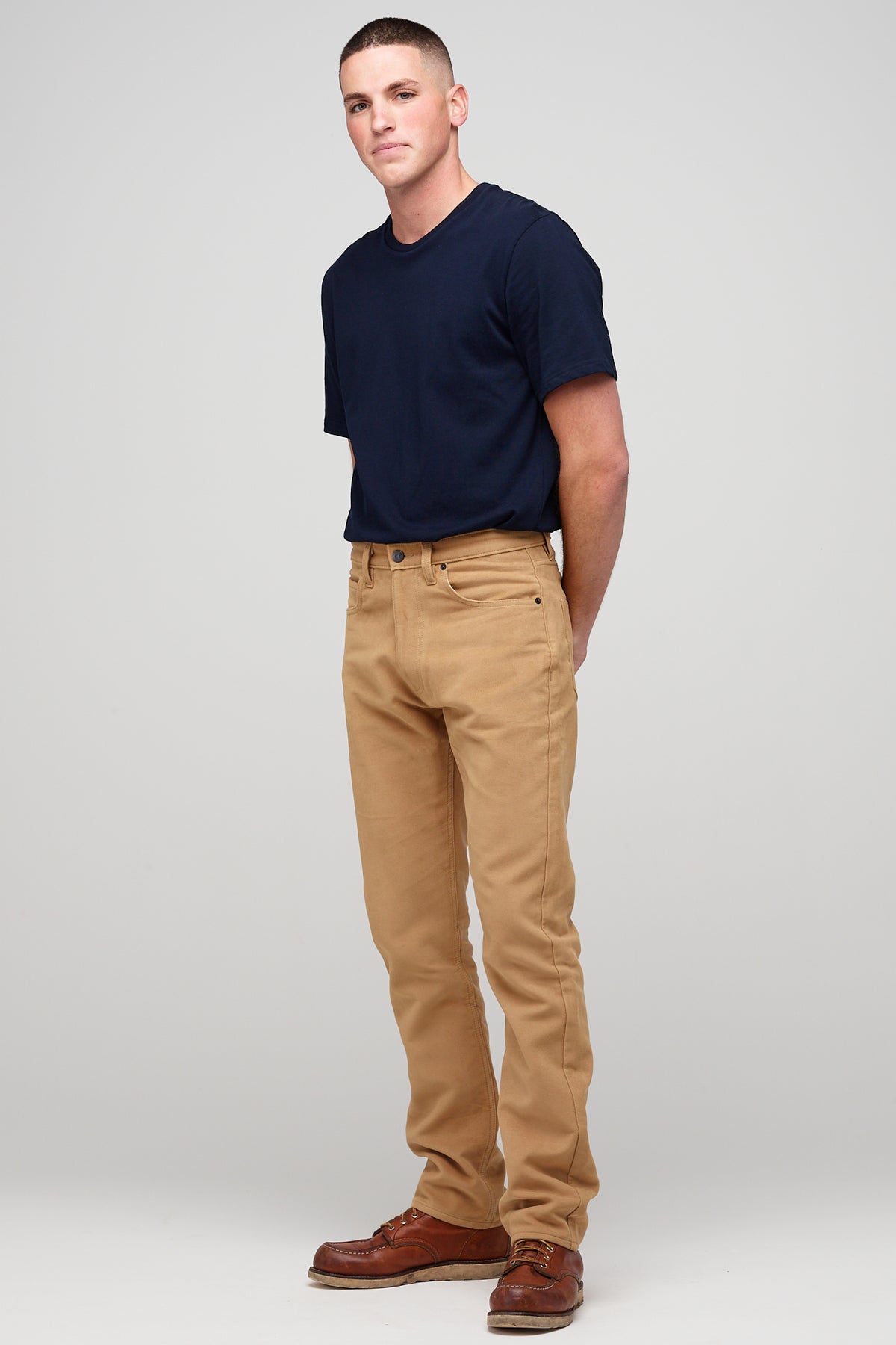 Male brunette wearing five pocket moleskin jeans in camel styled with black t-shirt