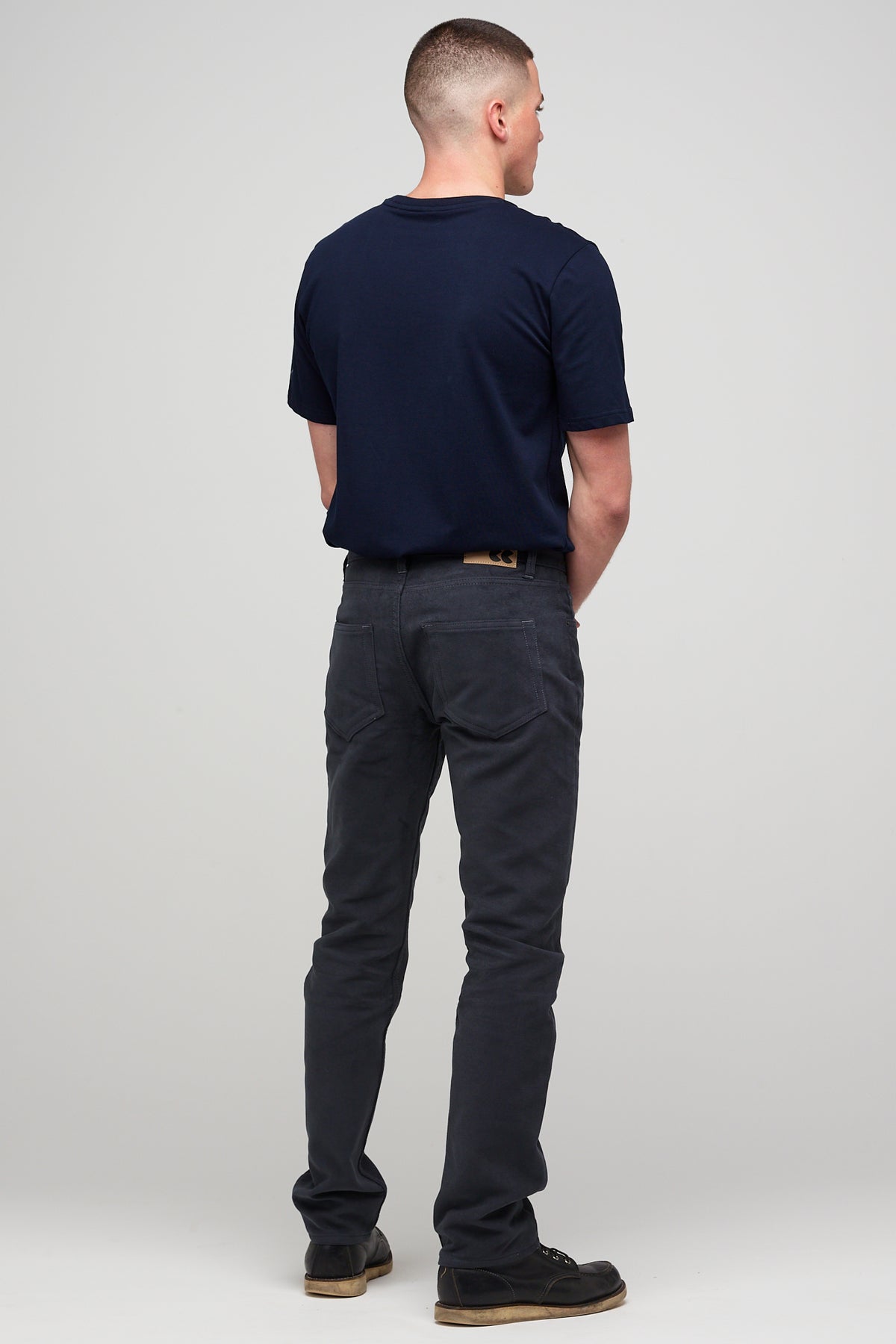 Brunette white male wearing navy Five Pocket Moleskin Jeans styled with navy short sleeve t-shirt and black shoes