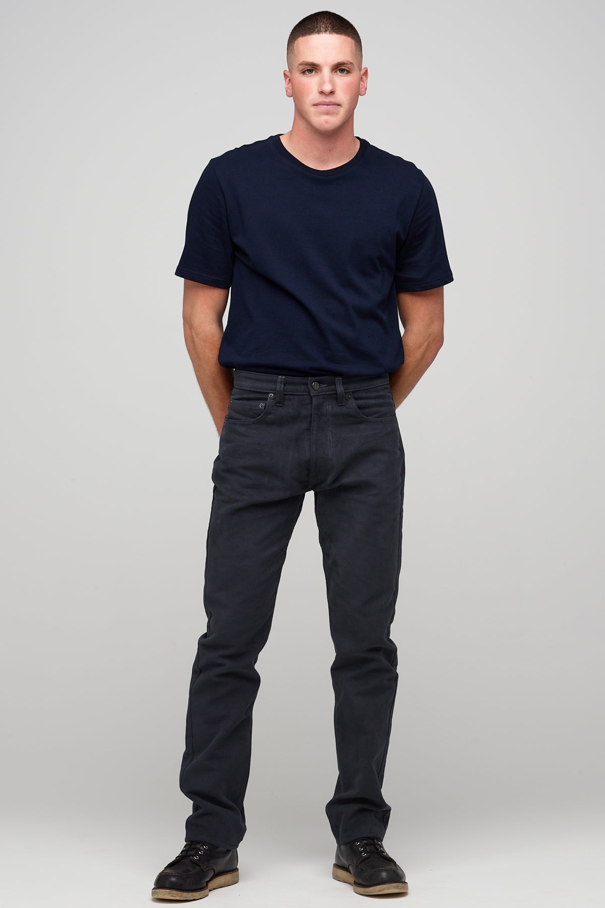 Brunette white male wearing navy Five Pocket Moleskin Jeans styled with navy short sleeve t-shirt and black shoes