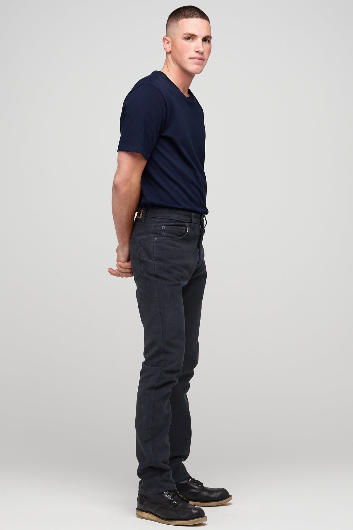 Brunette white male wearing navy Five Pocket Moleskin Jeans styled with navy short sleeve t-shirt and black shoes