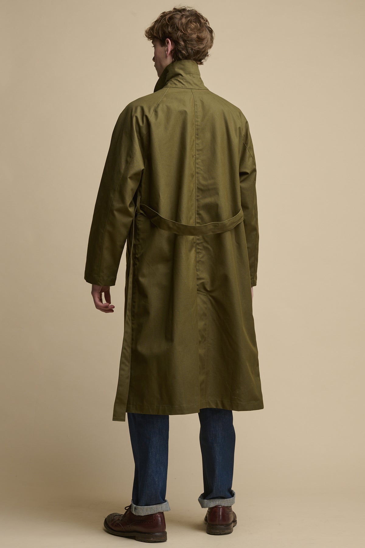 
            The back of men&#39;s Frank Raglan Raincoat in olive with collar up