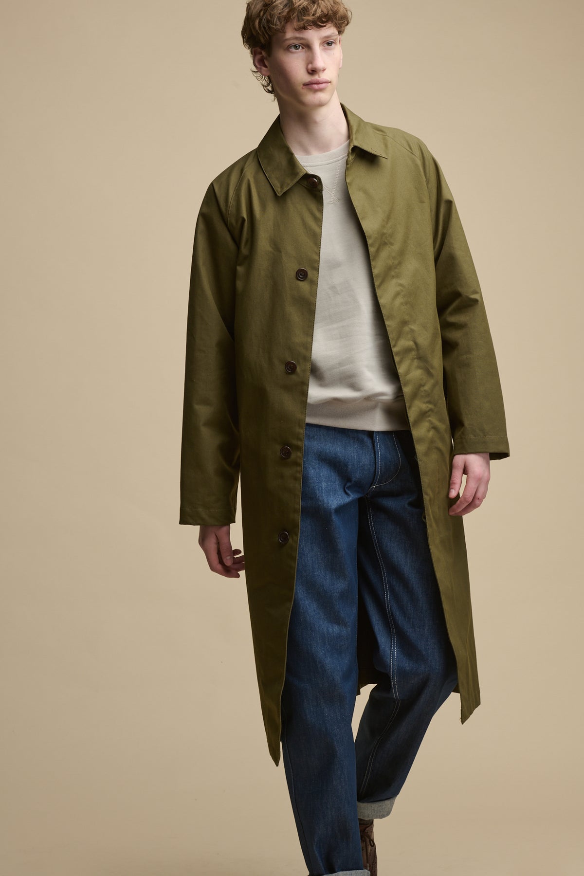 Full body image of the front of male wearing unfastened Frank Raglan Belted Raincoat in olive