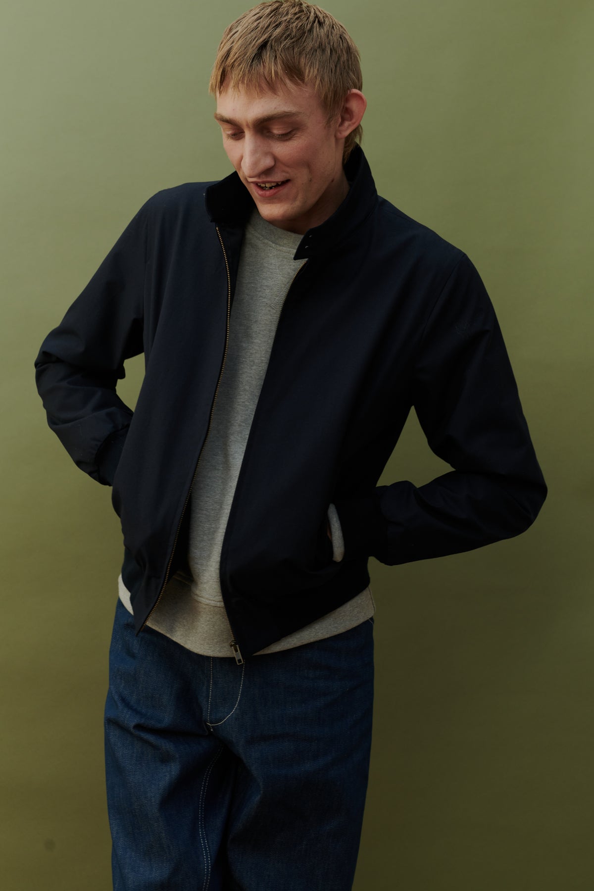 
            Blonde, white male wearing men&#39;s Harrington jacket in navy worn over grey raglan sweatshirt