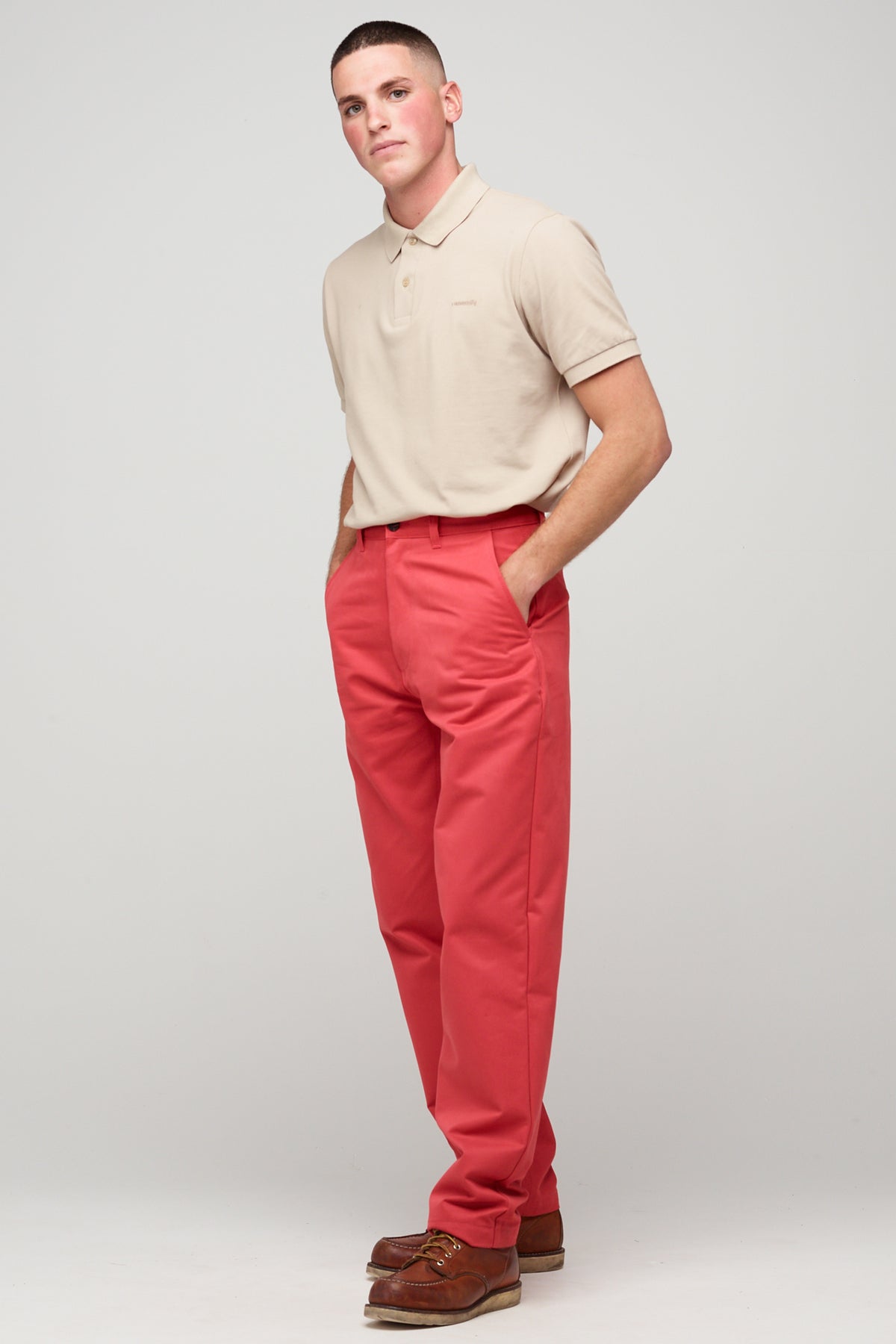 
            White, brunette male in salmon red, heavyweight relaxed chino styled with stone short sleeve polo shirt 