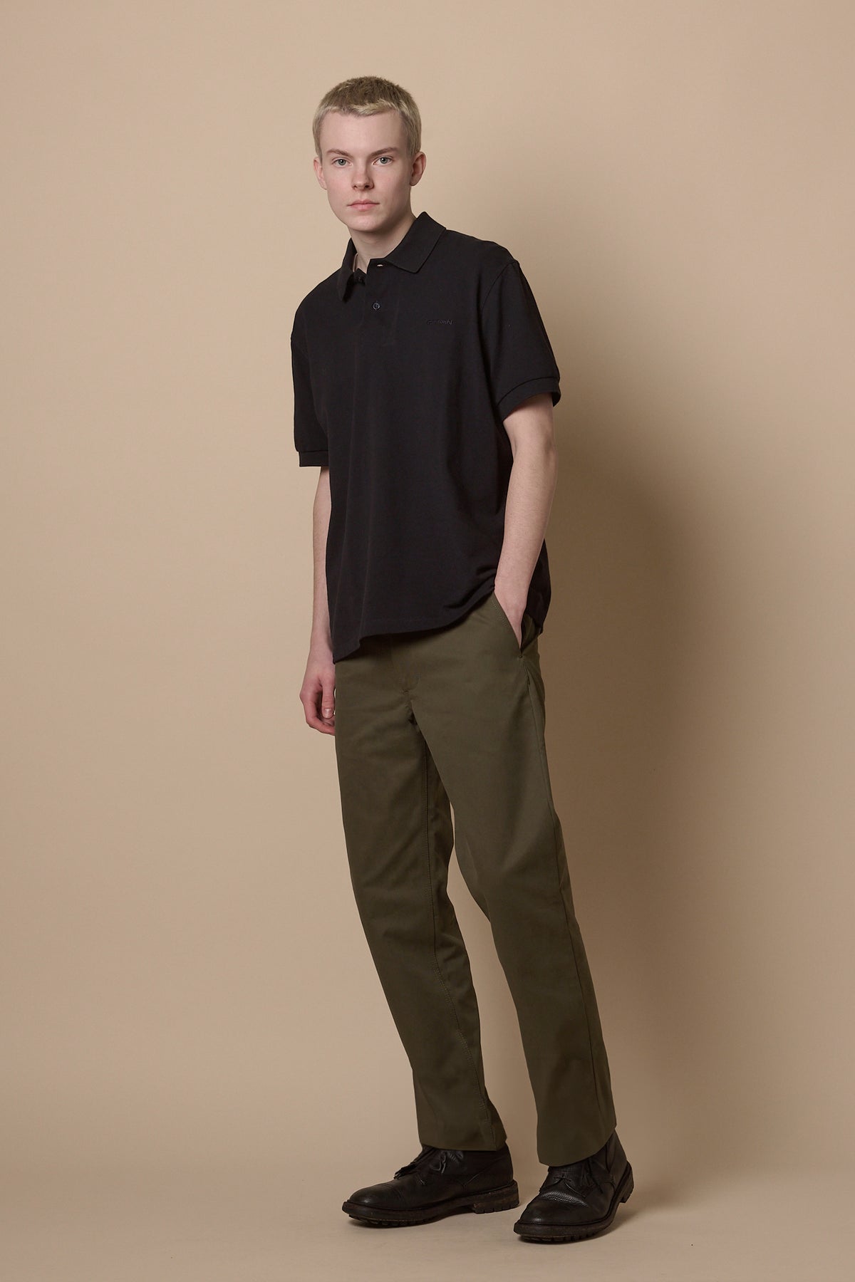 Full body image of male wearing heavyweight slim chino in olive paired with short sleeve polo shirt