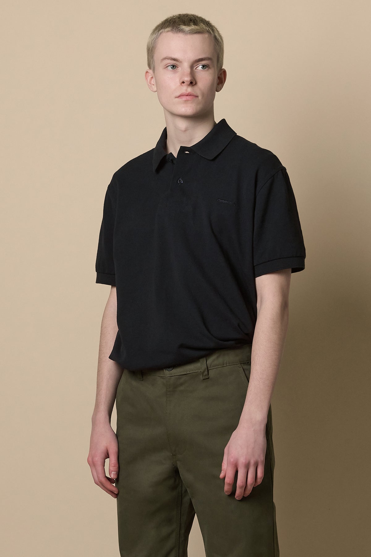 Knee up image of male wearing heavyweight slim chino in olive with short sleeve polo shirt