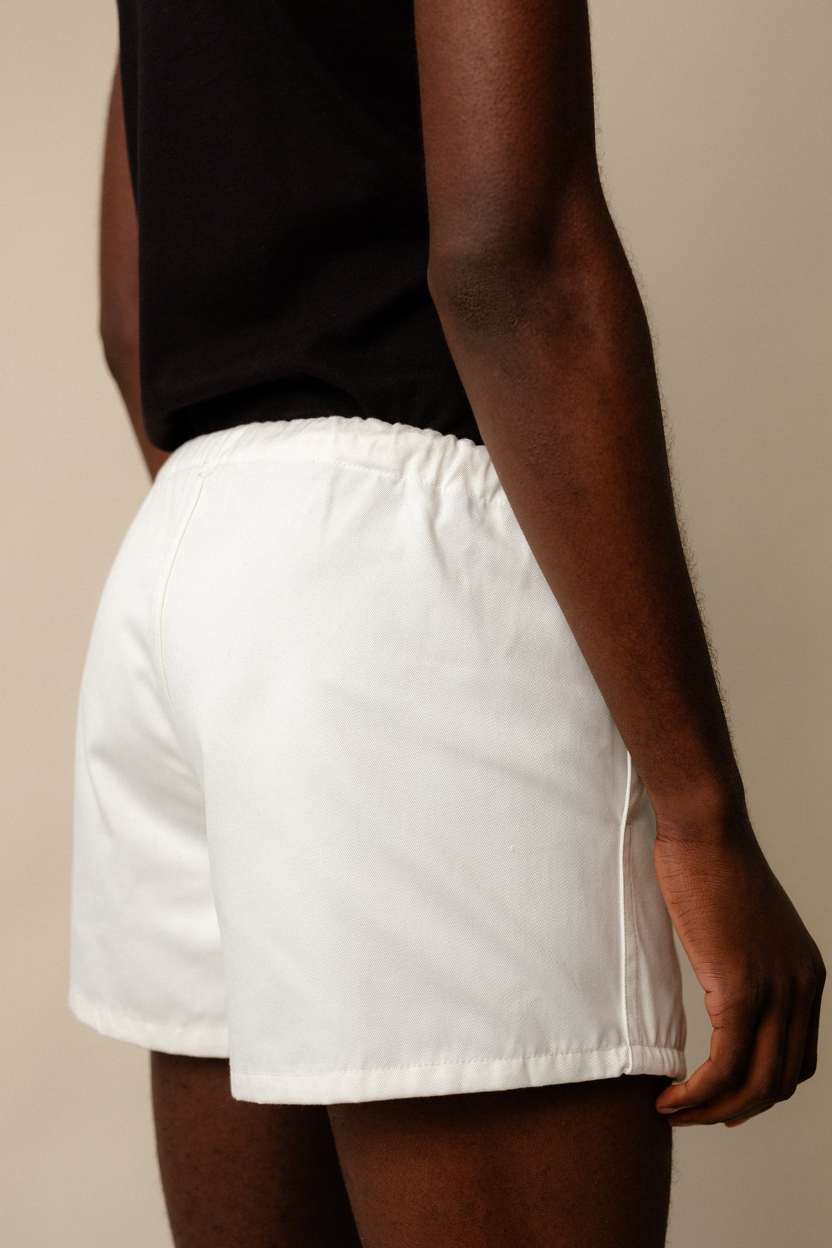 Male from behind wearing heavyweight sports short plastic free in white showing elasticated waistband