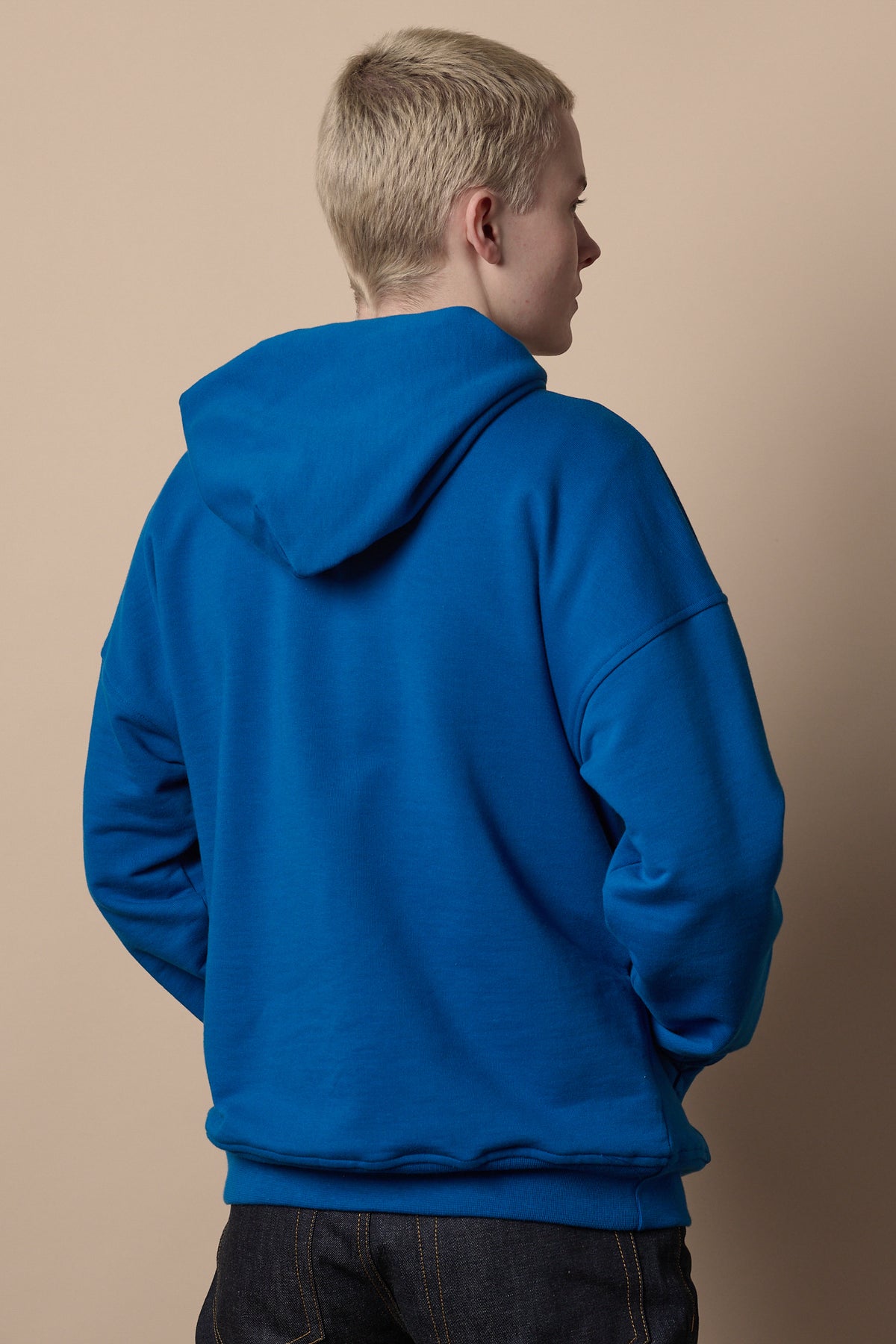 Back of white male wearing hooded sweatshirt in cobalt