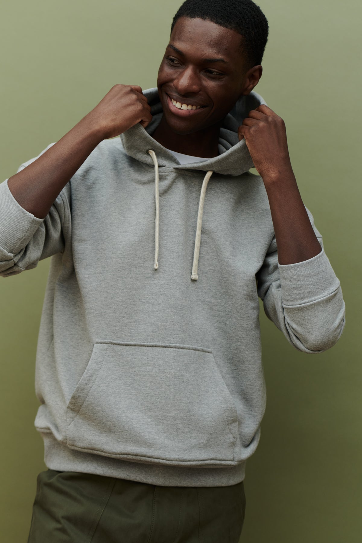 
            Thigh up image of black male wearing hooded sweatshirt in grey with one front pocket